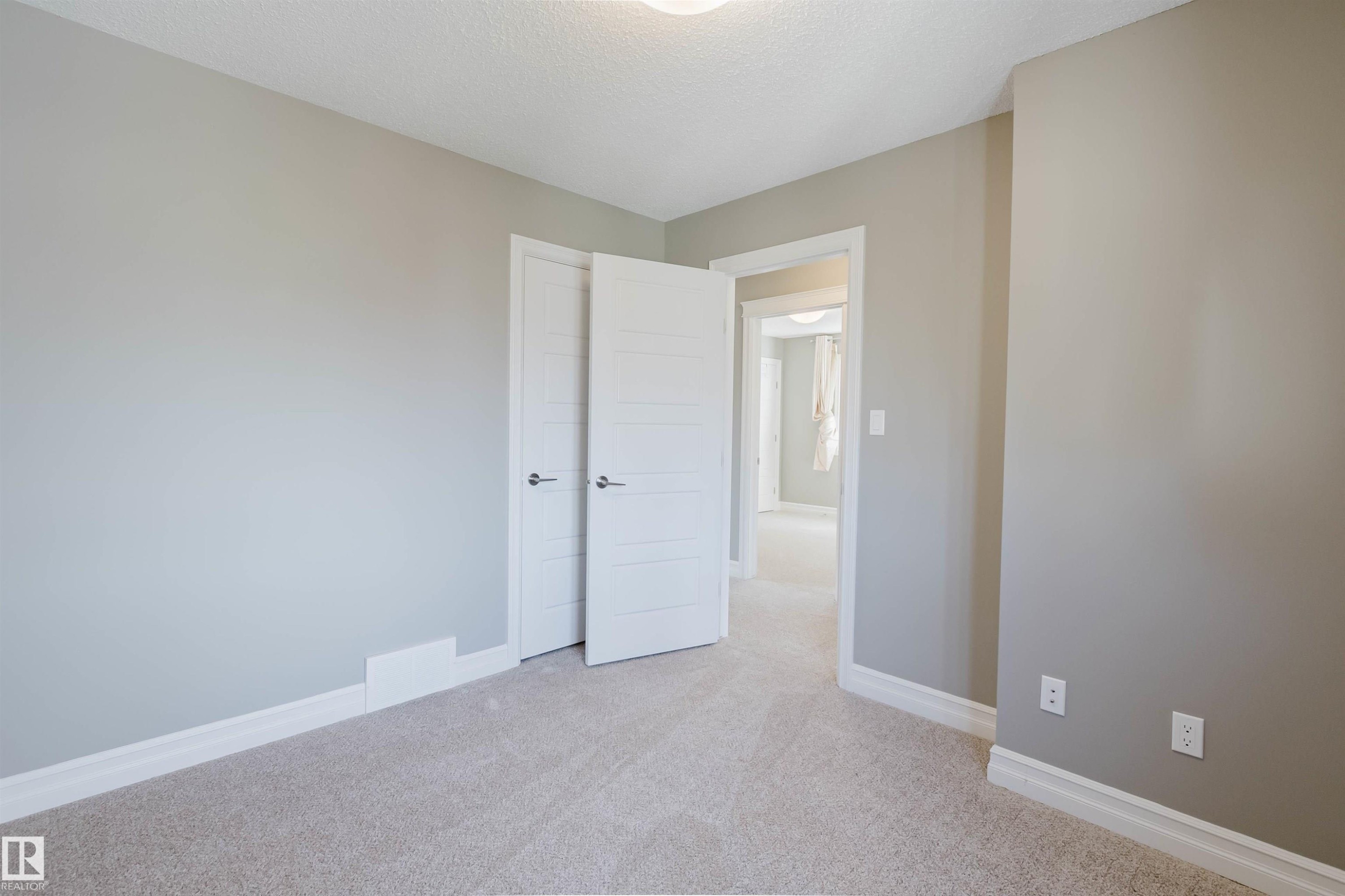 Neutral wall color, wall-to-wall carpeting, white trim, white interior doors, and overhead lighting - 15839 10 Avenue Sw, Edmonton, AB - Indoor Photo Showing Other Room