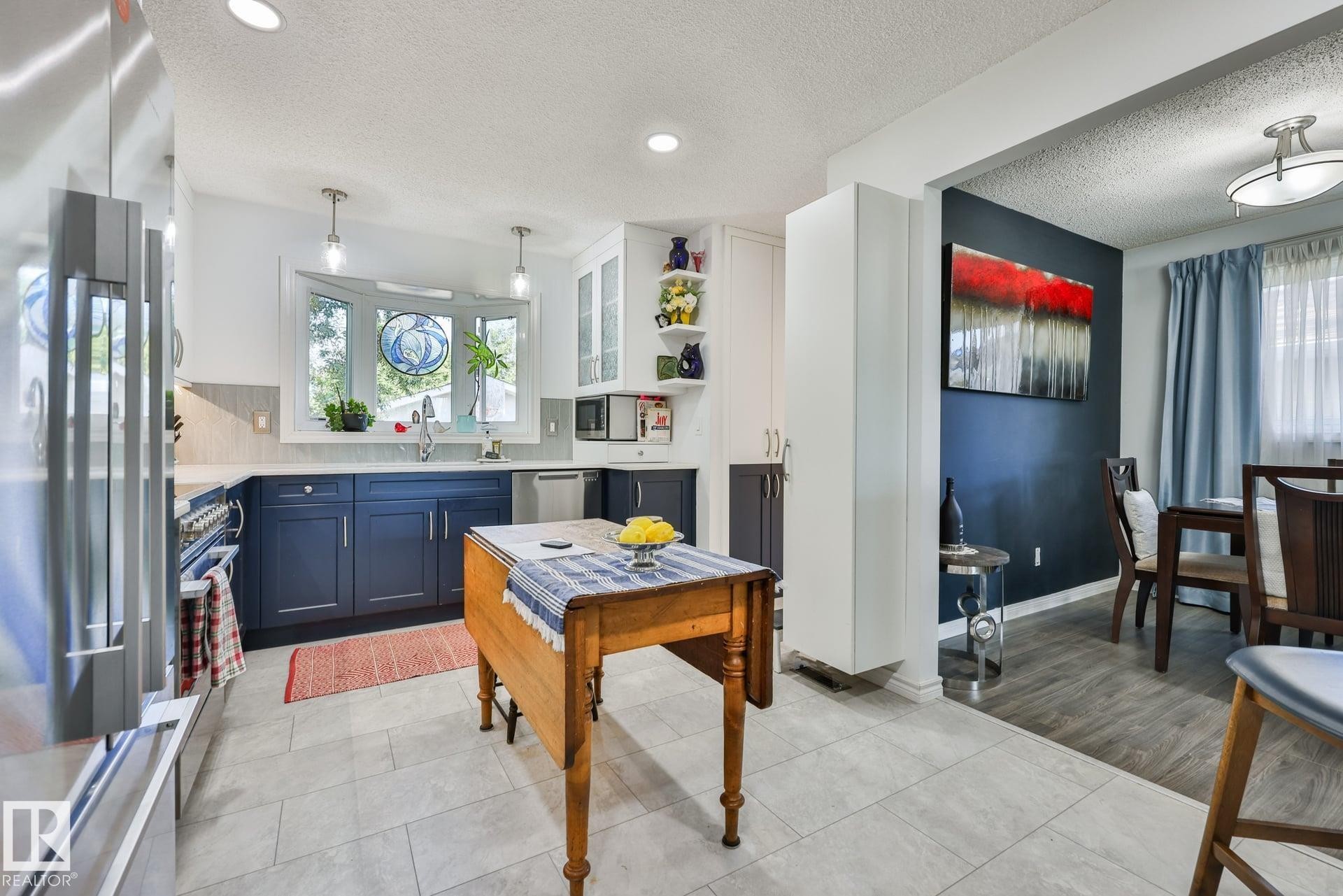 Kitchen with paneled cabinetry, stainless steel appliances, recessed lighting, and a bay window - 8932 187 Street Nw, Edmonton, AB - Indoor