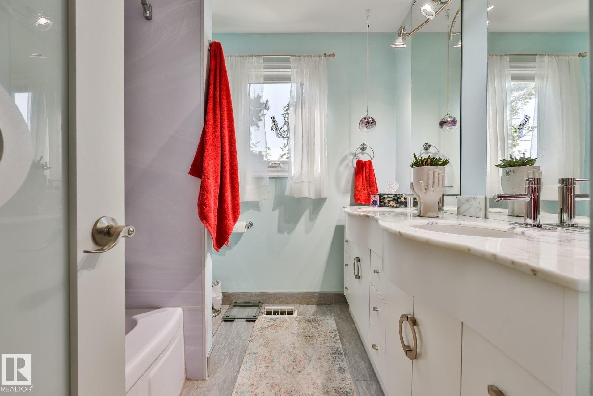 Dual-sink vanity with a light-toned countertop, recessed lighting, and a built-in bathtub - 8932 187 Street Nw, Edmonton, AB - Indoor Photo Showing Bathroom