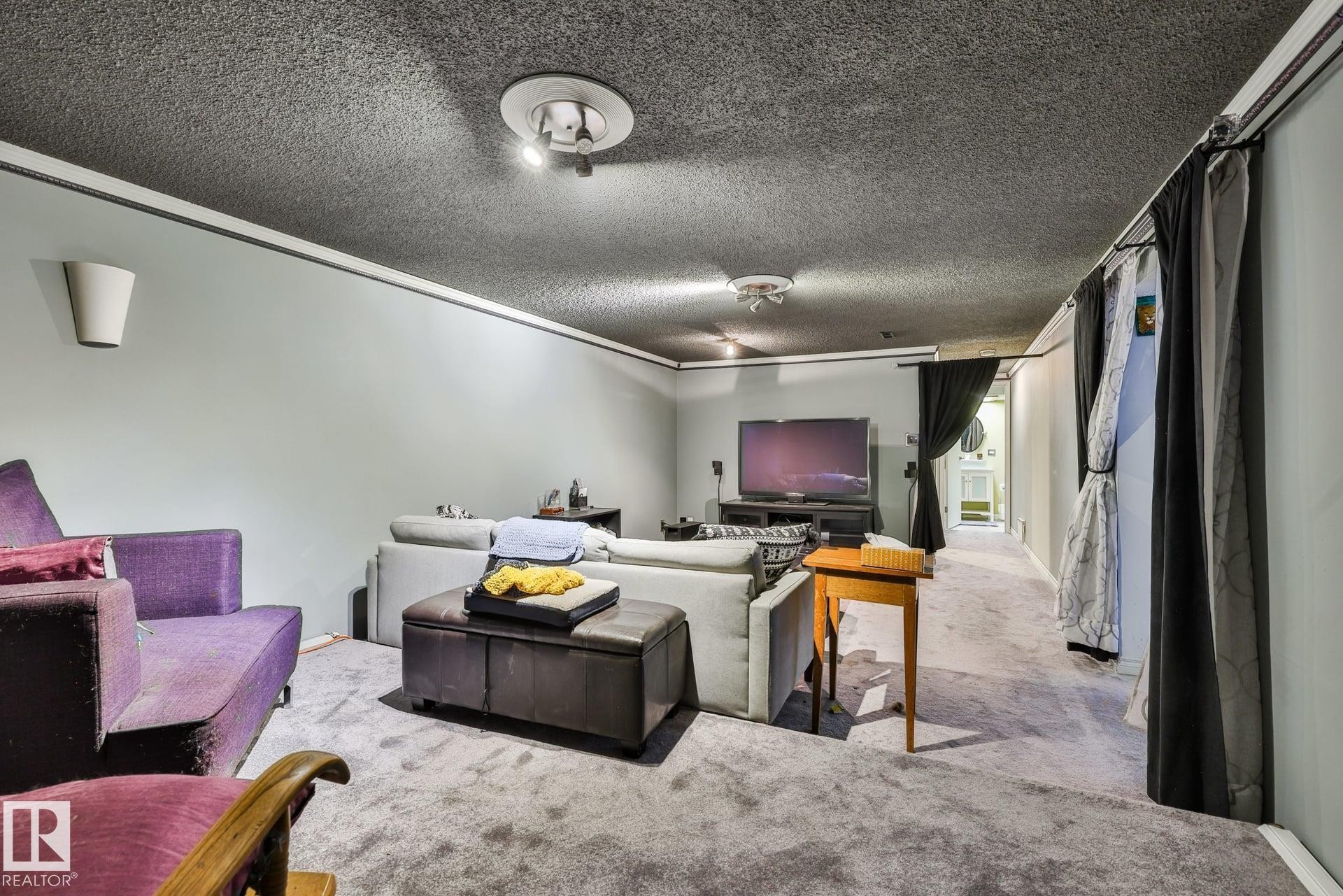 Recessed lighting, wall-mounted sconces, carpeted flooring, light gray wall paint, and ceiling-mounted track lighting - 8932 187 Street Nw, Edmonton, AB - Indoor Photo Showing Other Room