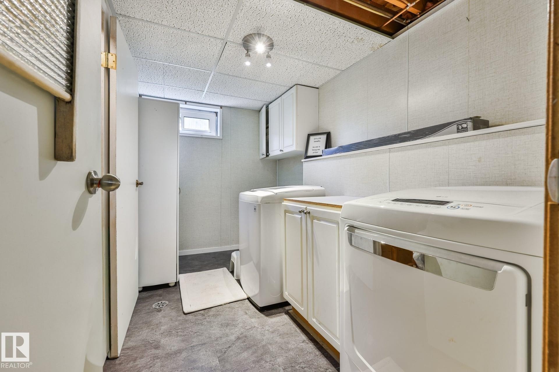 Dedicated laundry area featuring a washer, dryer, built-in cabinetry, and a ceiling-mounted light fixture - 8932 187 Street Nw, Edmonton, AB - Indoor Photo Showing Laundry Room