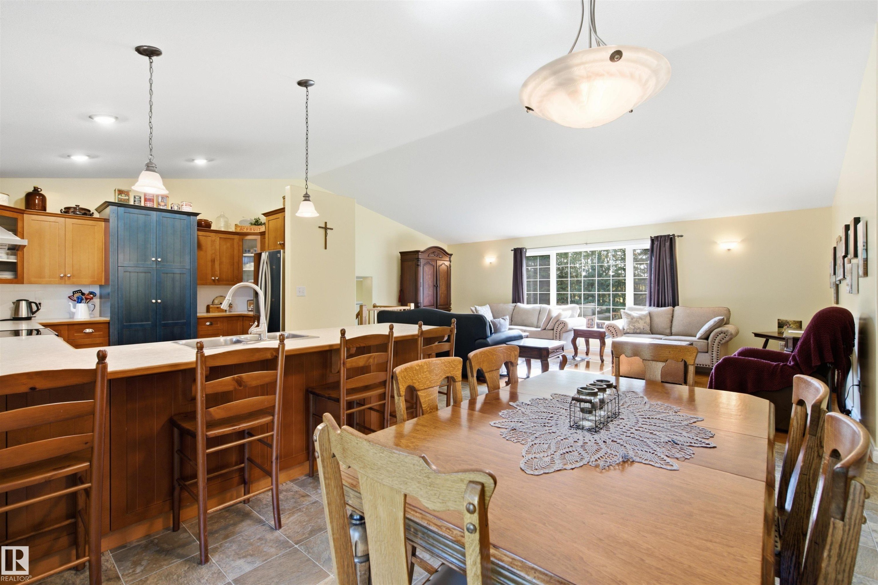 Open-concept living space featuring vaulted ceilings and a peninsula with seating - 59125 Range Road 102, Rural St. Paul County, AB - Indoor Photo Showing Dining Room