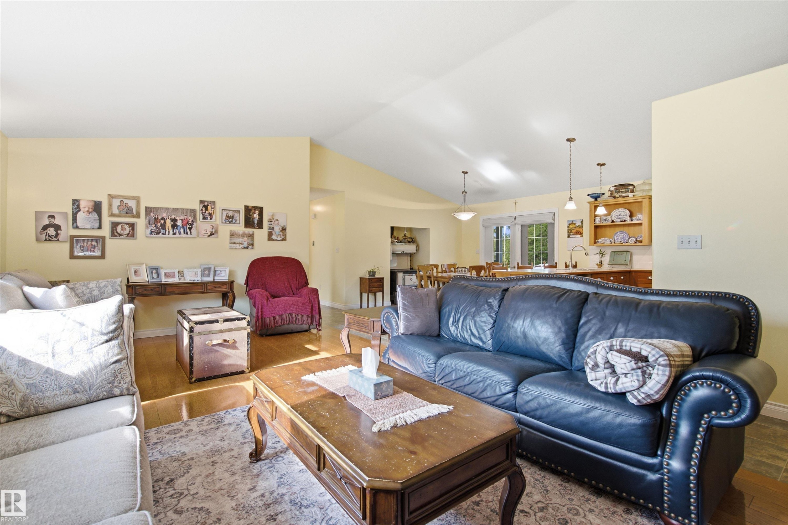 Bright living area featuring vaulted ceilings, wood-finish flooring, and warm neutral wall tones - 59125 Range Road 102, Rural St. Paul County, AB - Indoor Photo Showing Living Room