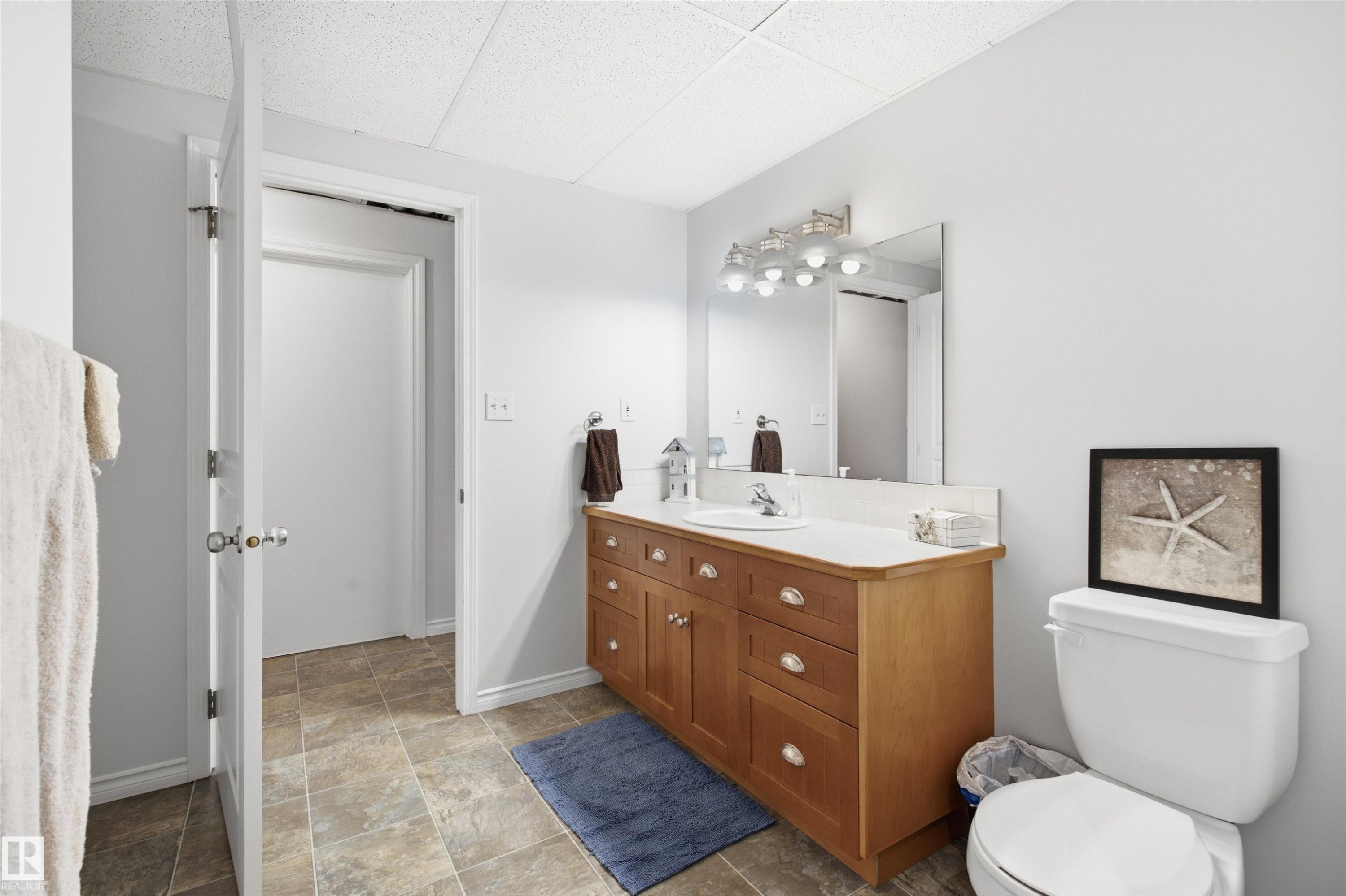 Bathroom featuring a light wood-finish vanity with a white countertop and integrated sink - 59125 Range Road 102, Rural St. Paul County, AB - Indoor Photo Showing Bathroom