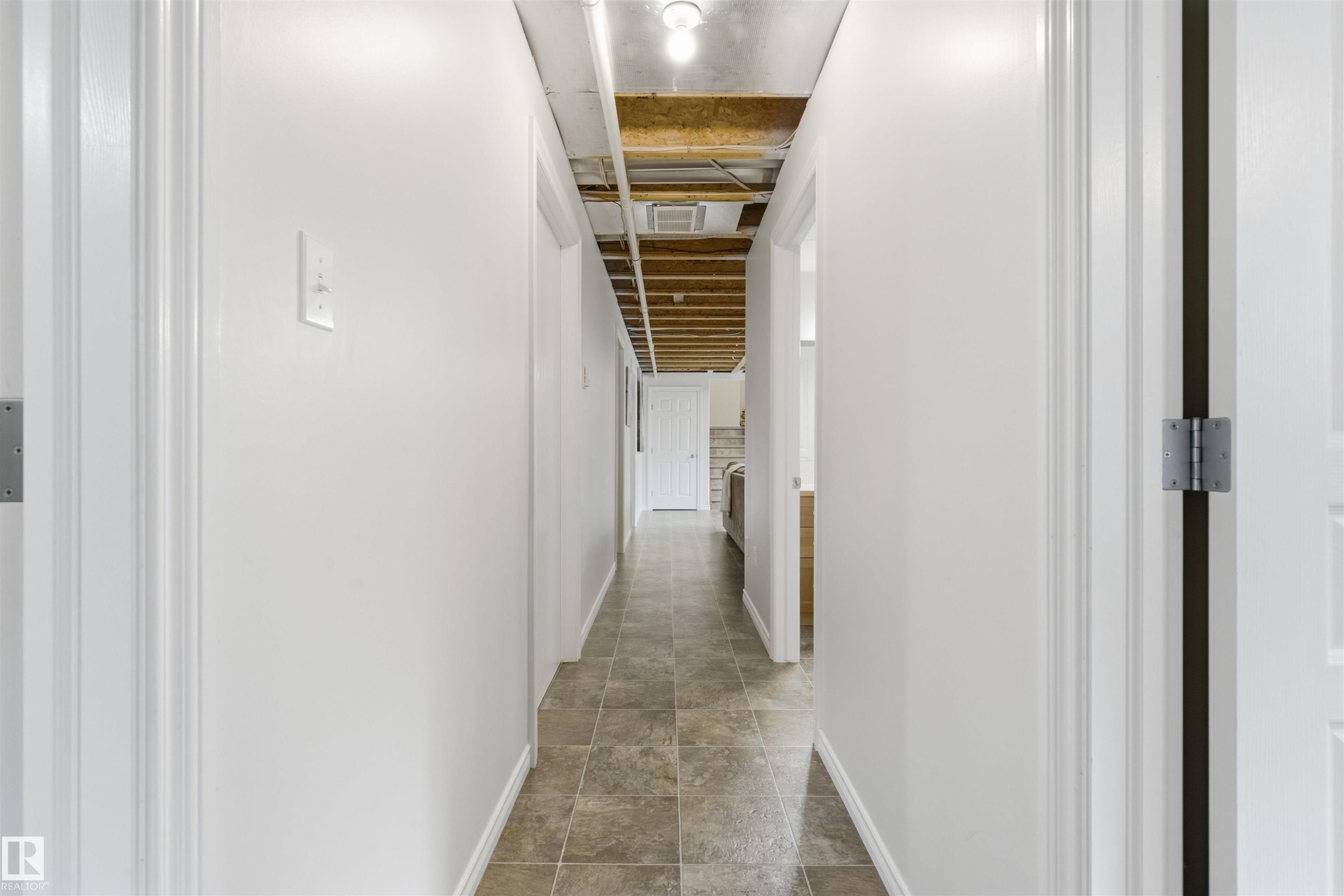 Hallway with light-toned tile flooring, white painted walls, and white trim - 59125 Range Road 102, Rural St. Paul County, AB - Indoor Photo Showing Other Room