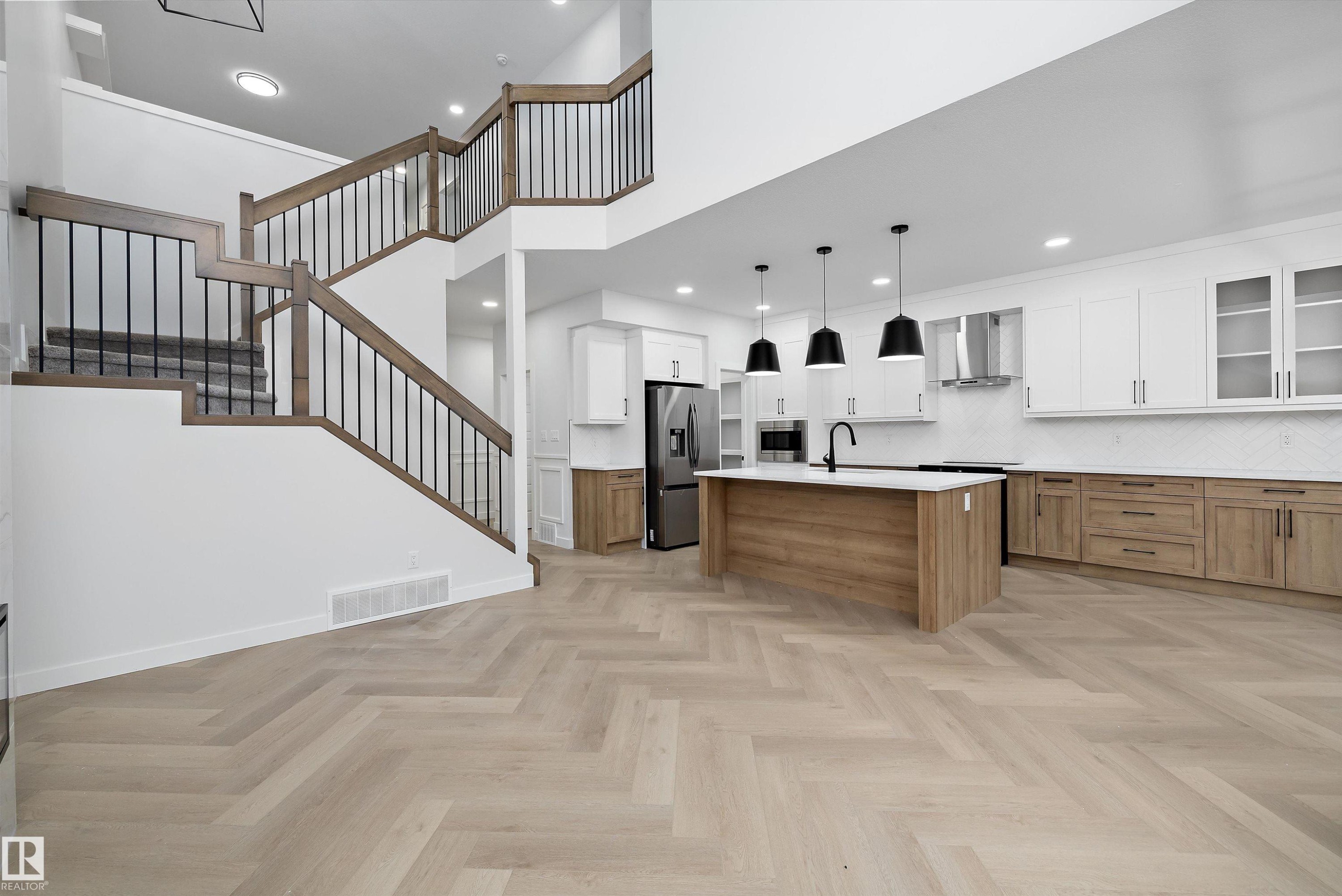 Herringbone wood-finish flooring complements the two-tone kitchen cabinetry - 971 Elderberry Landing Nw, Edmonton, AB - Indoor Photo Showing Other Room