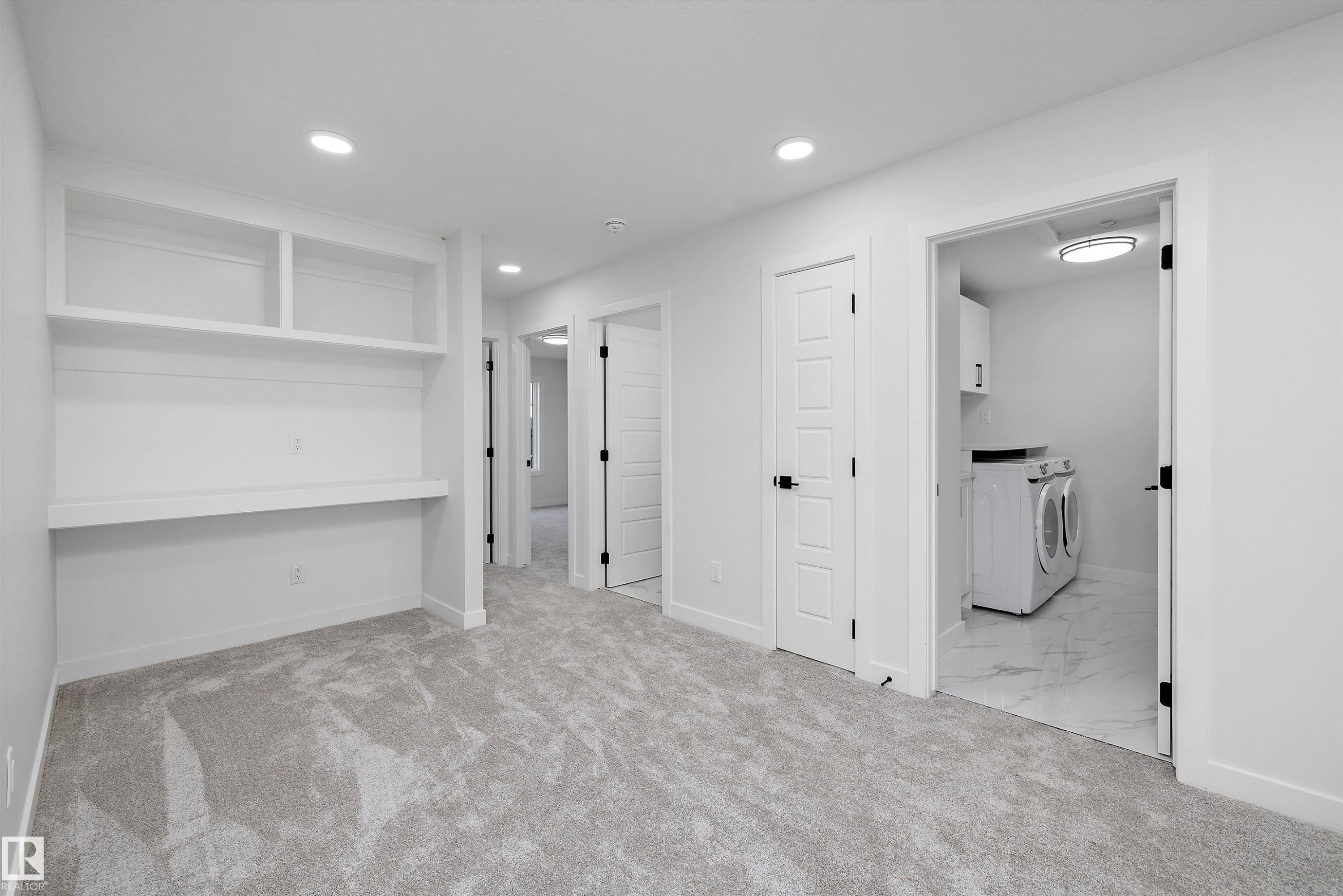 Built-in shelving and desk, recessed lighting, panel doors with matte black hardware, and carpet flooring - 971 Elderberry Landing Nw, Edmonton, AB - Indoor Photo Showing Other Room