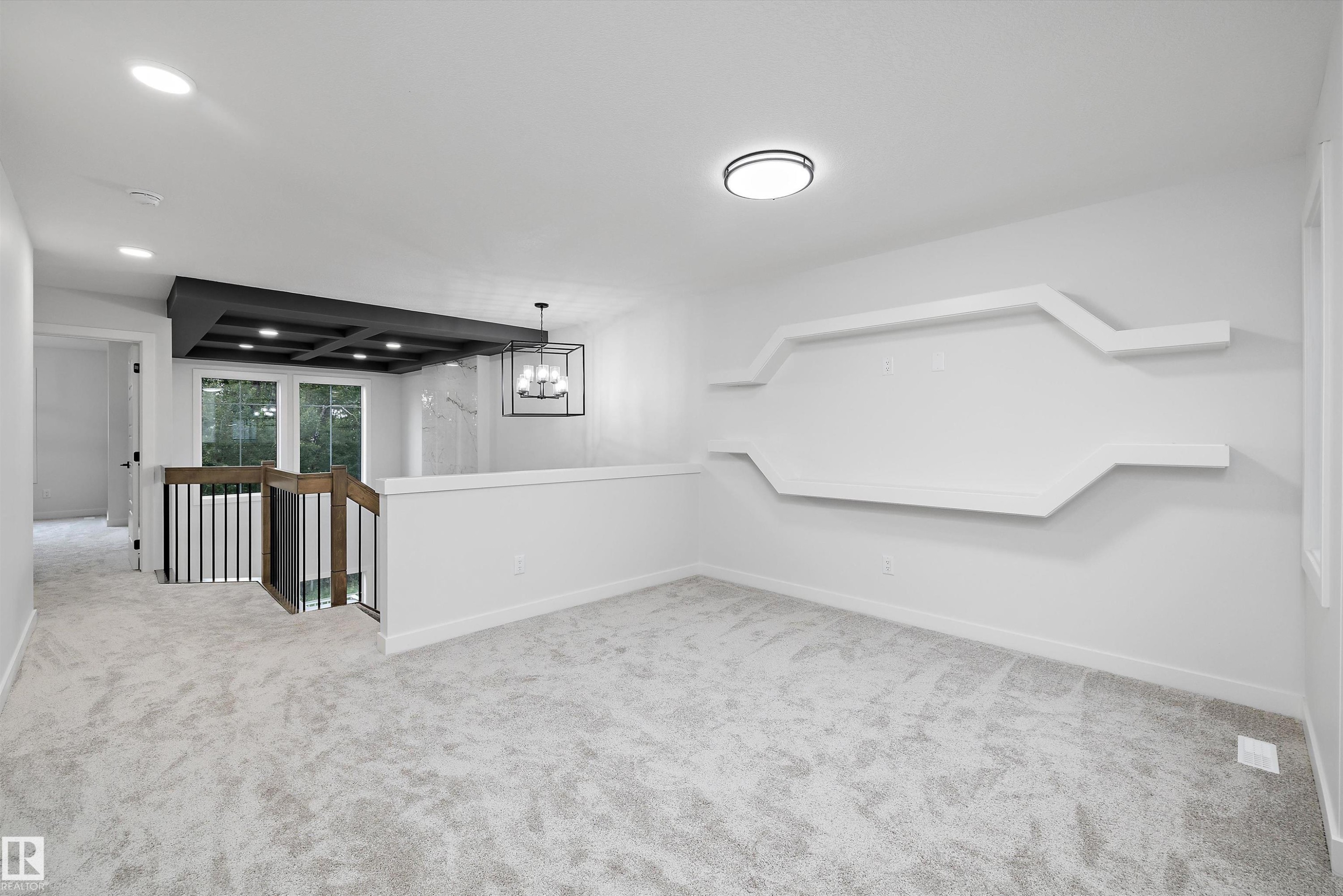 White wall with integrated decorative shelving, flush mount ceiling fixture, and light gray carpeted flooring - 971 Elderberry Landing Nw, Edmonton, AB - Indoor Photo Showing Other Room