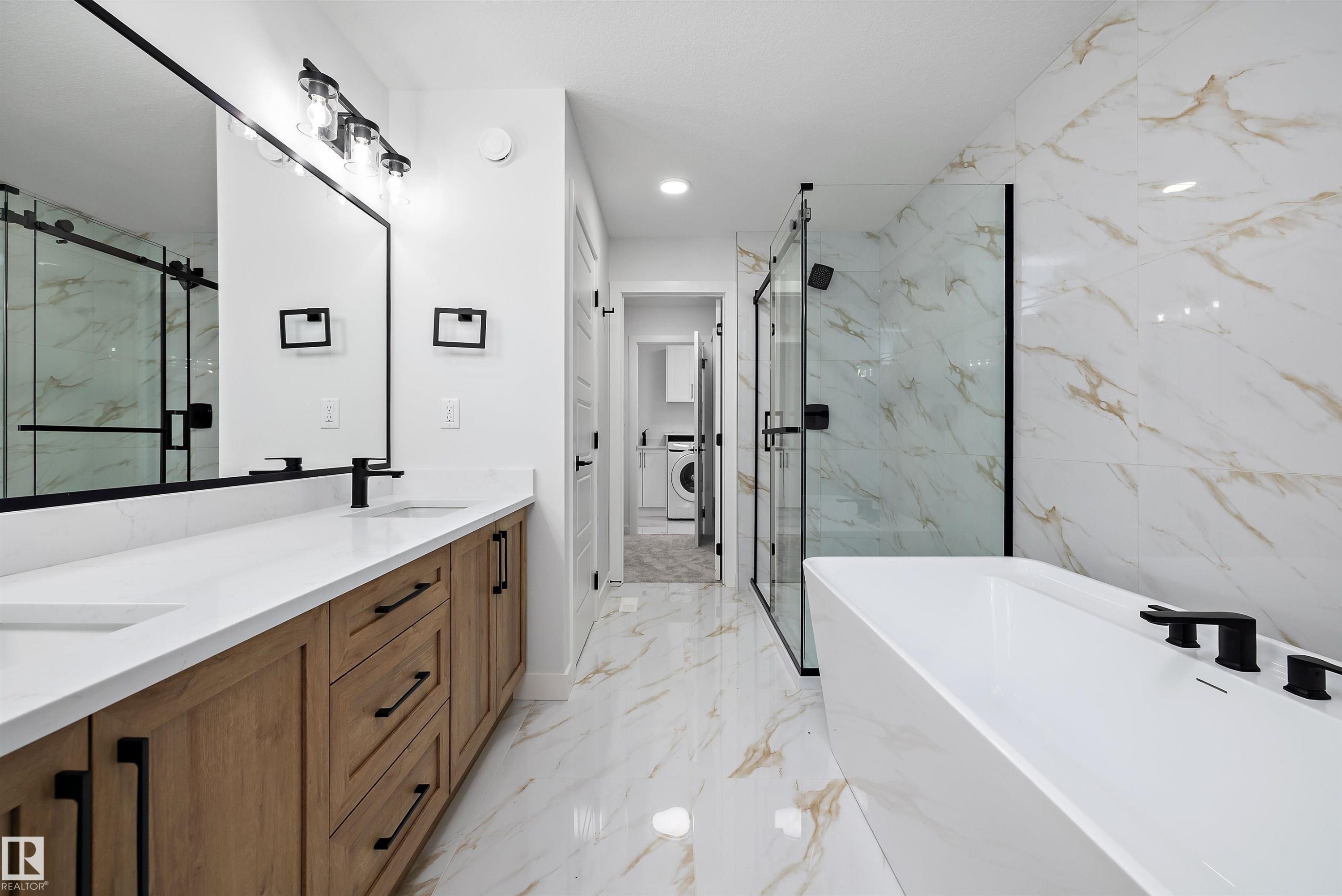 Dual vanity with wood-finish cabinetry, white countertops, and matte black fixtures - 971 Elderberry Landing Nw, Edmonton, AB - Indoor Photo Showing Bathroom