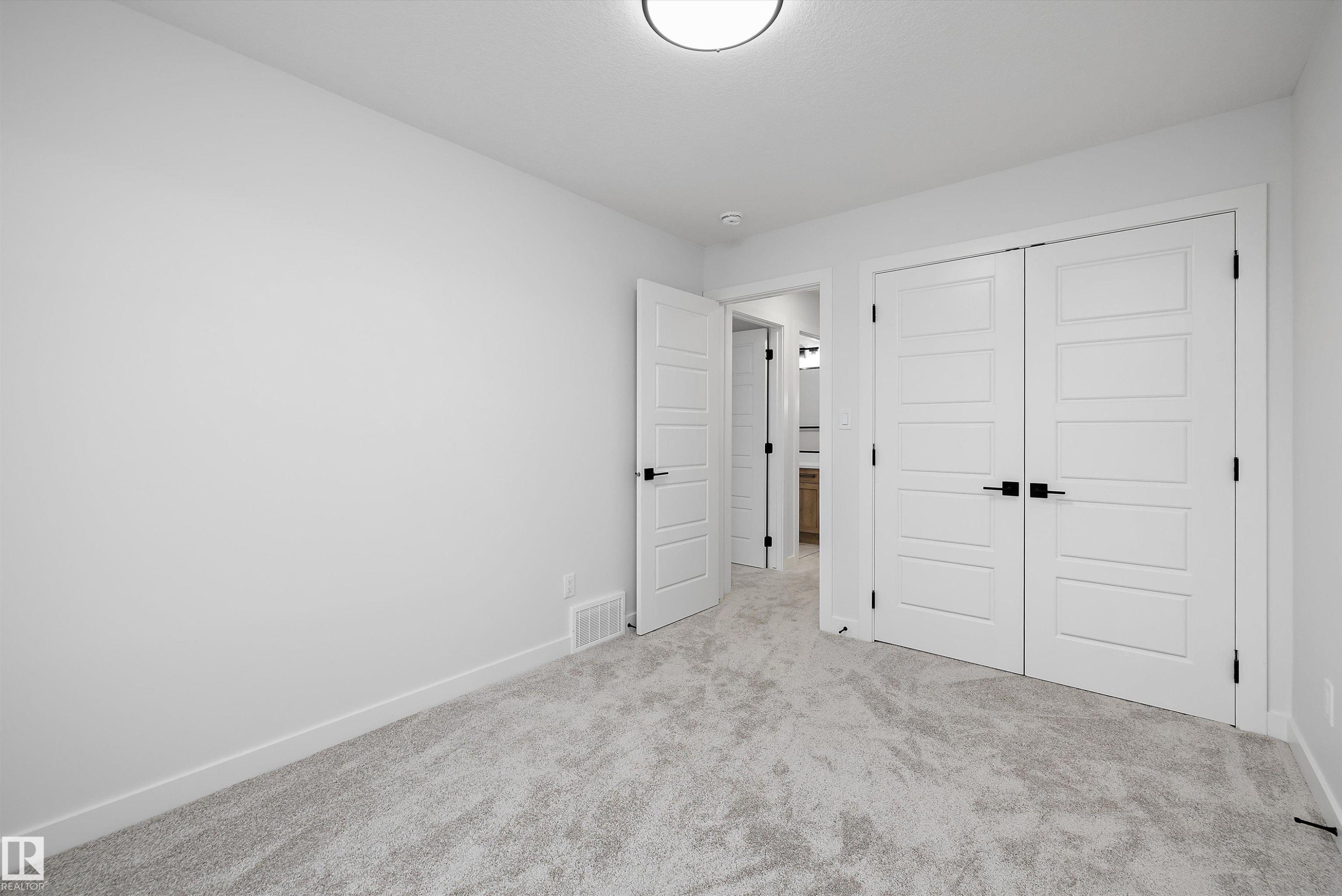 Light grey carpeted flooring, white walls, and a flush mount ceiling light - 971 Elderberry Landing Nw, Edmonton, AB - Indoor Photo Showing Other Room