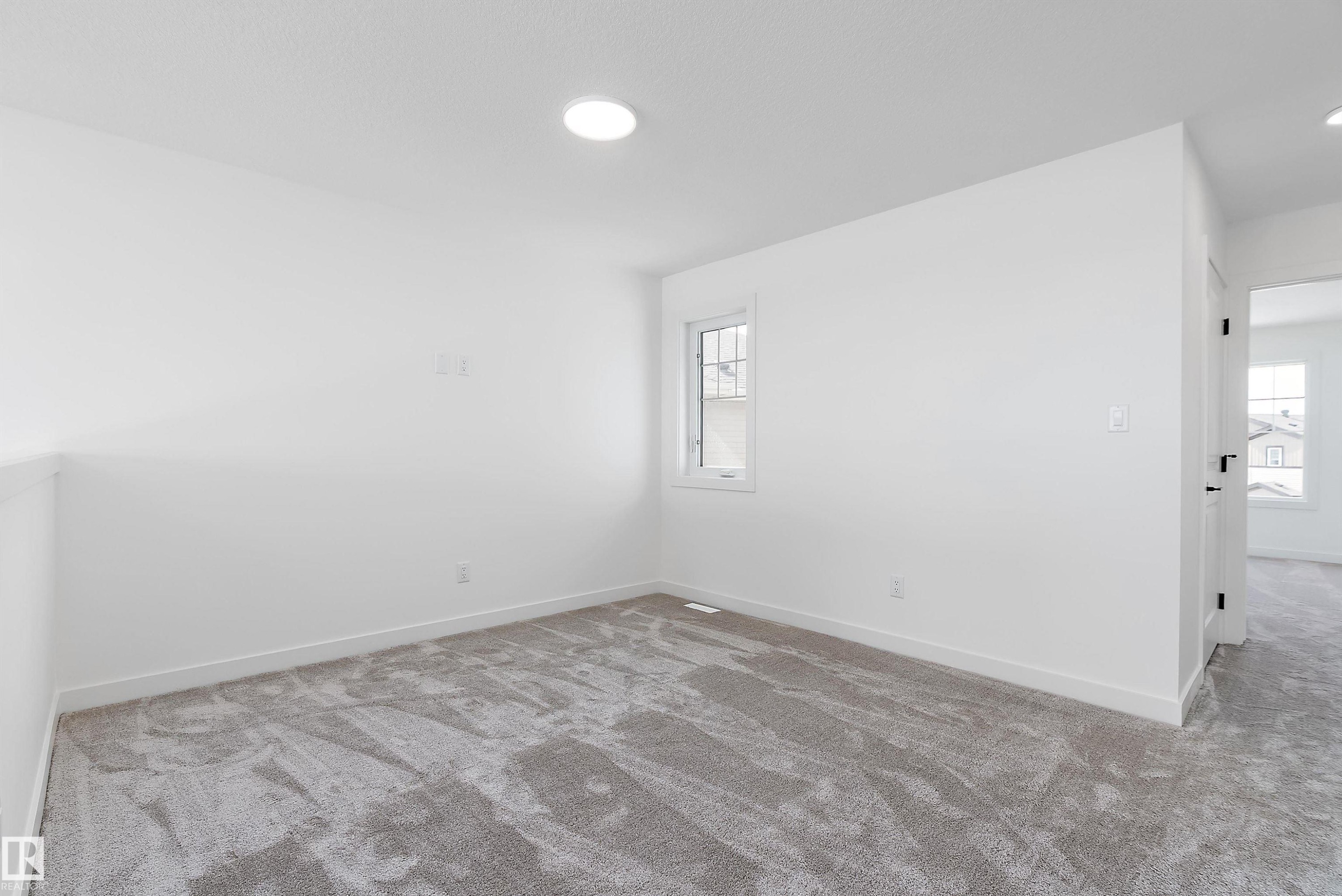 Recessed ceiling lighting, white painted walls, window with white trim, gray patterned carpeting, and white baseboards - 1763 Crossbill Loop Nw, Edmonton, AB - Indoor Photo Showing Other Room