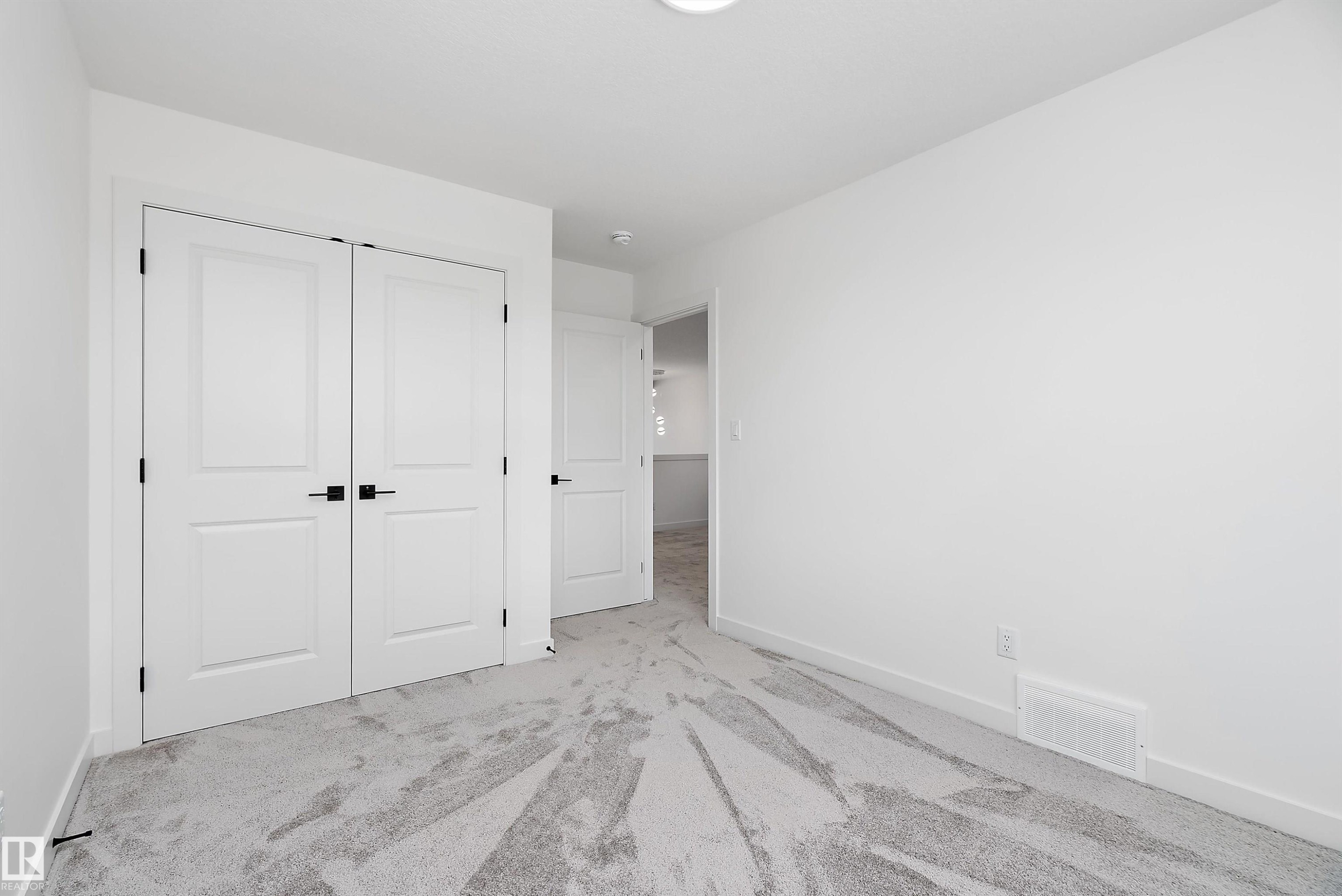 White walls with a light-colored carpet featuring a subtle pattern - 1763 Crossbill Loop Nw, Edmonton, AB - Indoor Photo Showing Other Room