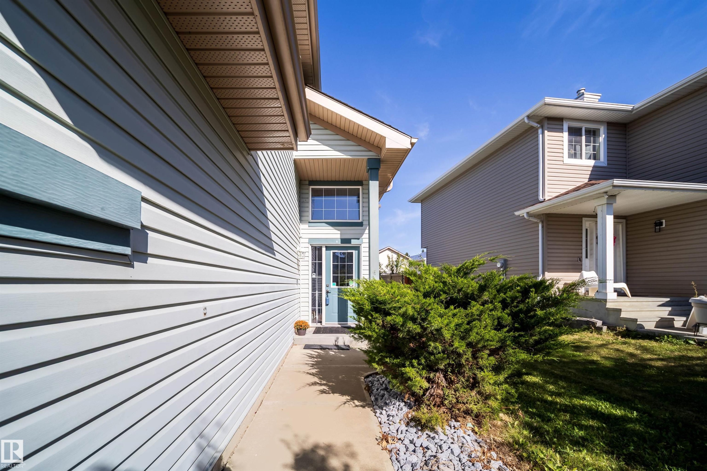 Light-colored siding exterior with contrasting trim accents - 7848 7 Avenue Sw, Edmonton, AB