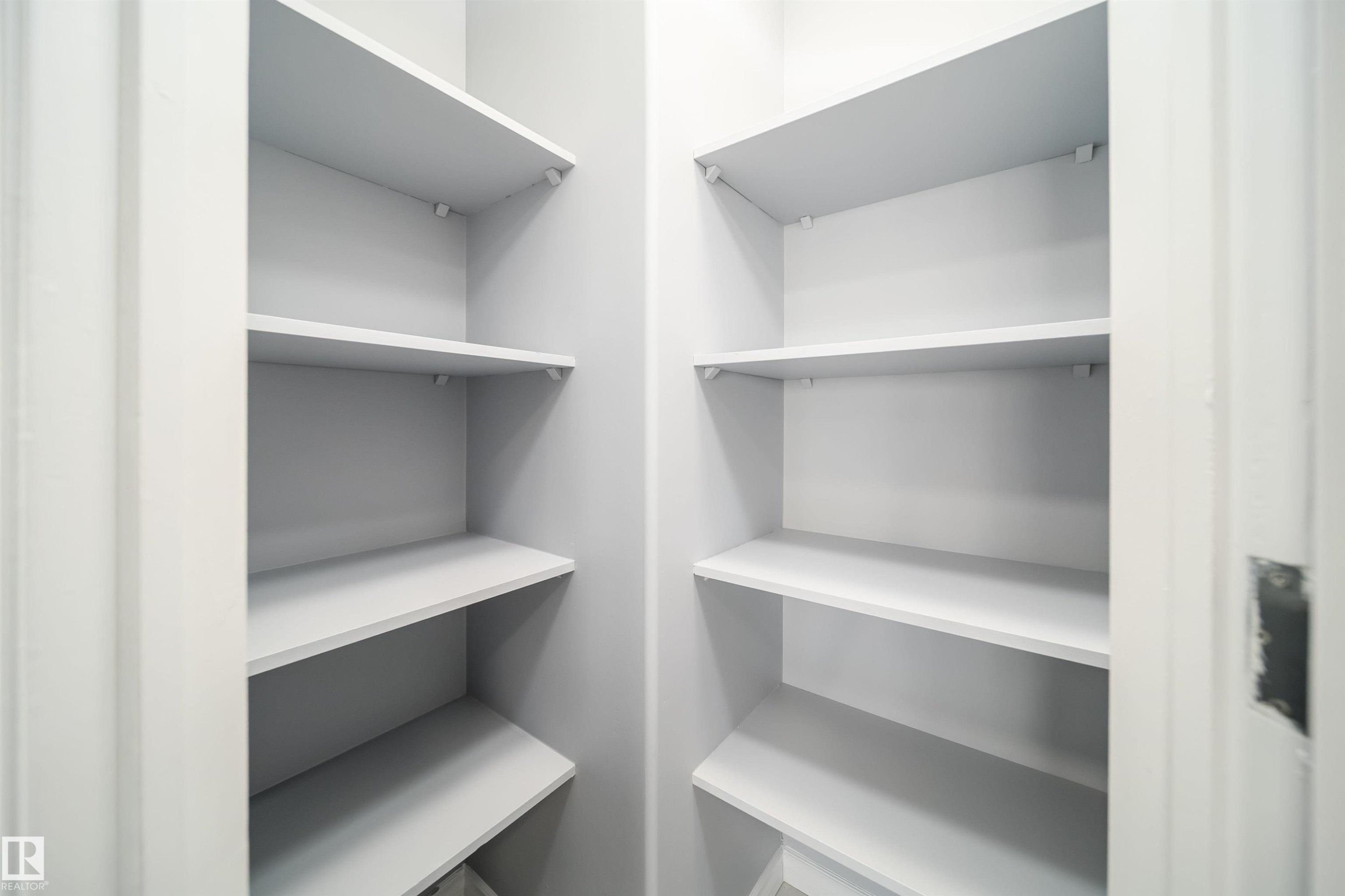 Built-in shelving with multiple levels, white finish, and corner configuration - 7848 7 Avenue Sw, Edmonton, AB