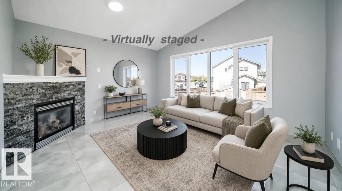 Accent wall with a built-in fireplace featuring a stone surround - 7848 7 Avenue Sw, Edmonton, AB