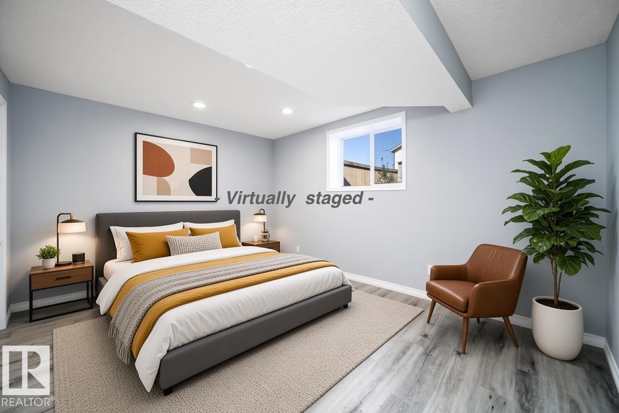 Recessed ceiling lighting, light blue wall paint, wood-finish flooring, white window trim, and white ceiling - 7848 7 Avenue Sw, Edmonton, AB