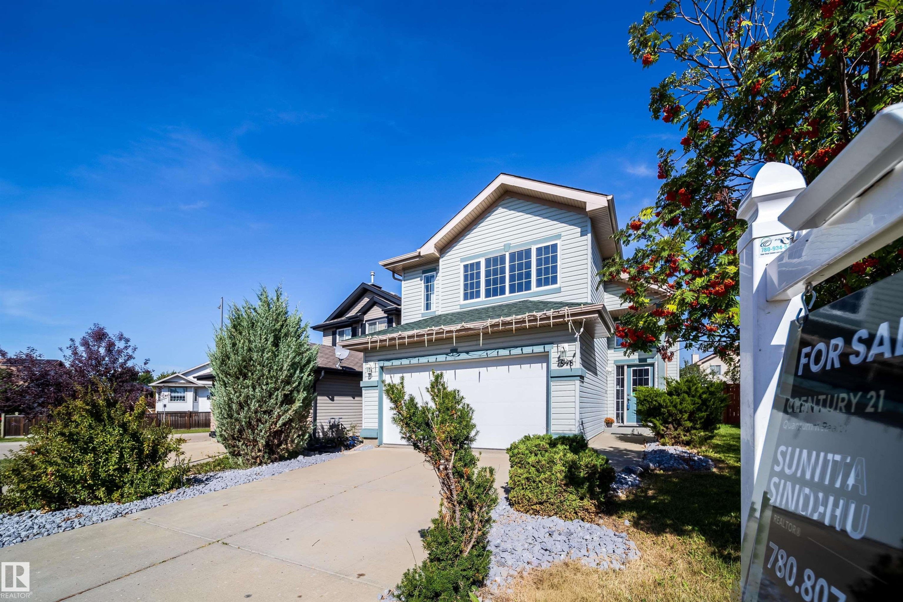 Two-story residence featuring light-colored siding, a two-car garage, and multiple windows - 7848 7 Avenue Sw, Edmonton, AB