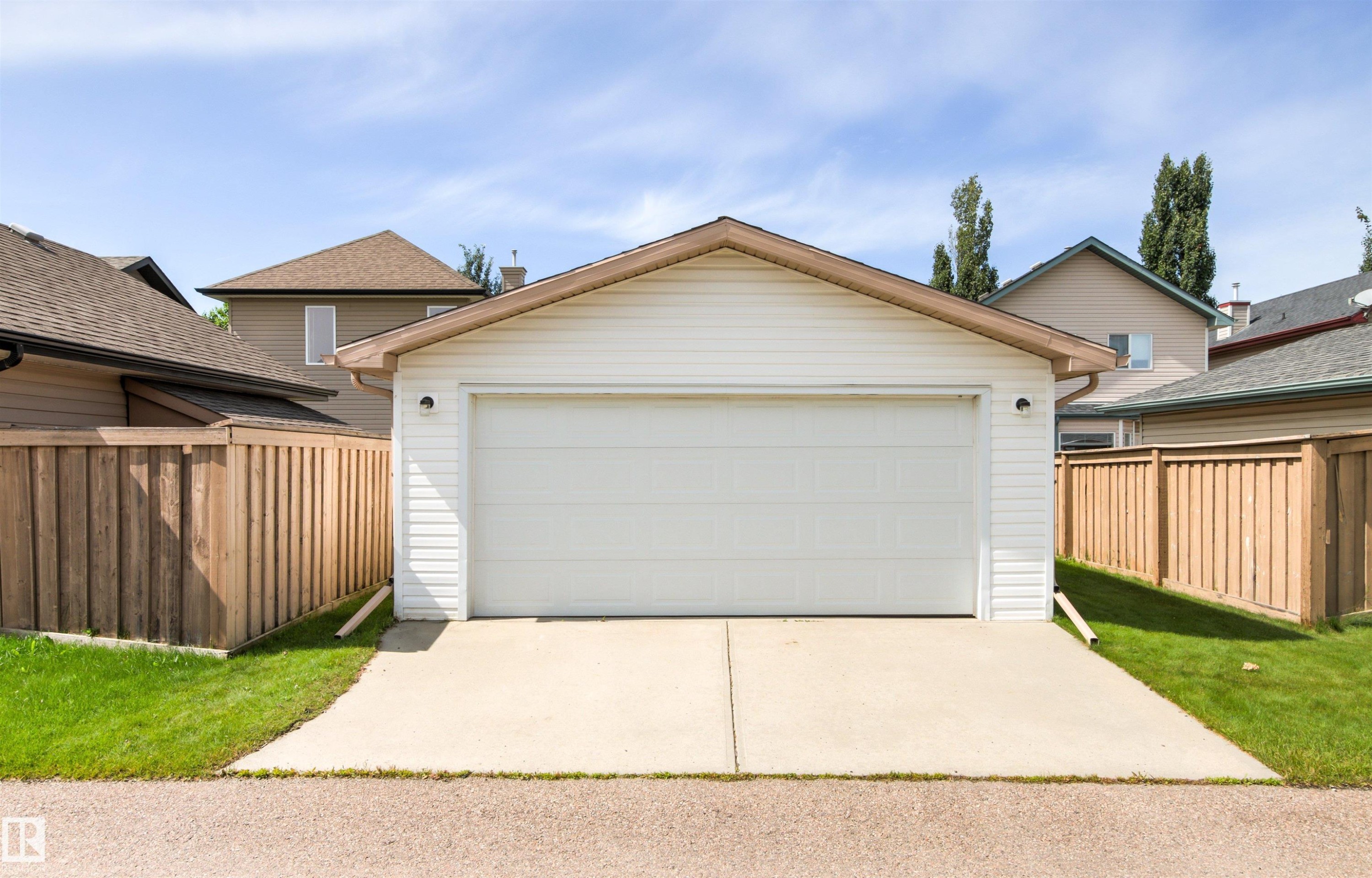 Detached garage featuring white siding, a single overhead door, and a concrete driveway - 9118 Scott Crescent Nw, Edmonton, AB - Outdoor With Exterior