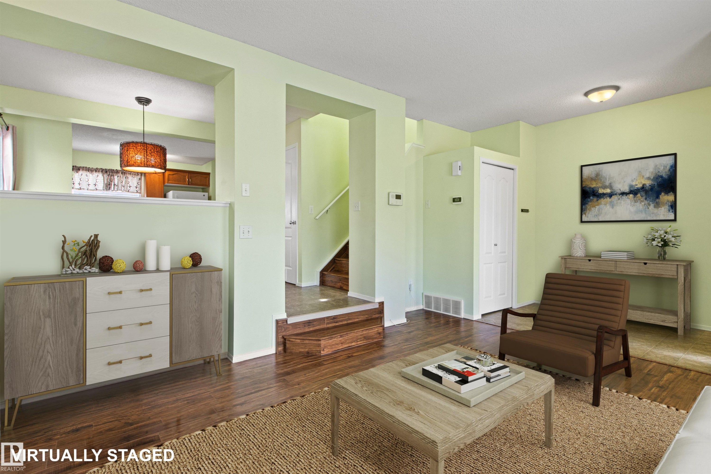 Wood-finish flooring throughout, light green wall finishes, and a bi-fold closet door - 9118 Scott Crescent Nw, Edmonton, AB - Indoor Photo Showing Living Room