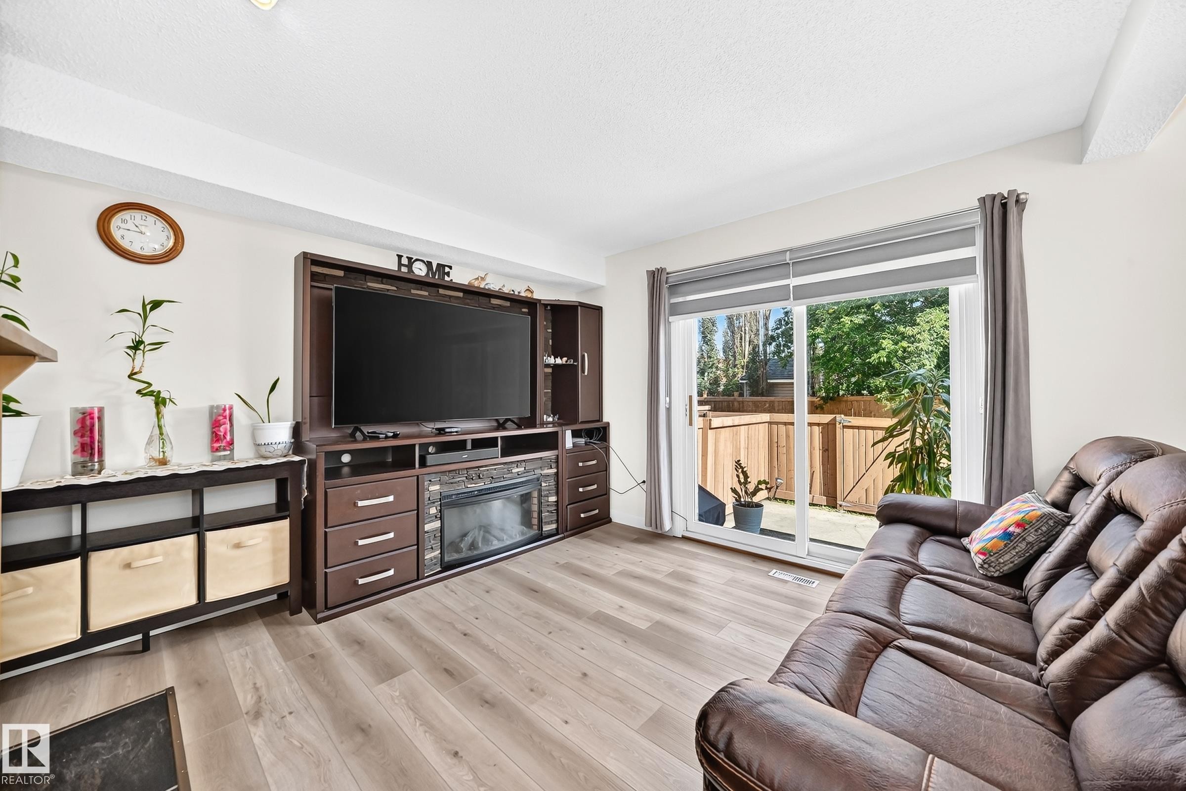 Wood-finish flooring throughout, bright white walls, and a recessed ceiling light - #22 3812 20 Av Nw, Edmonton, AB - Indoor Photo Showing Living Room