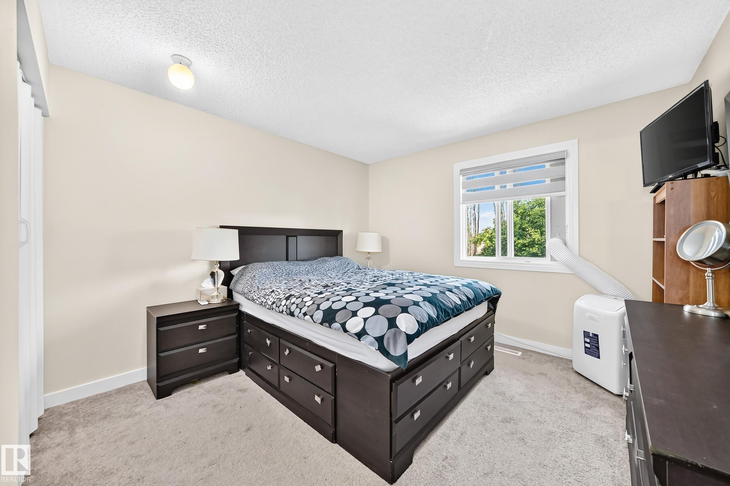 Neutral-toned walls complement the light-colored carpeting - #22 3812 20 Av Nw, Edmonton, AB - Indoor Photo Showing Bedroom