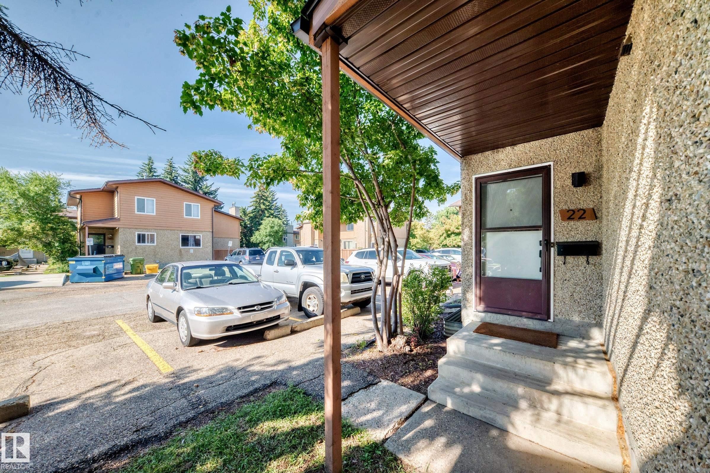 Concrete steps with a textured exterior, covered entry, and a contrasting front door - #22 3812 20 Av Nw, Edmonton, AB - Outdoor With Exterior