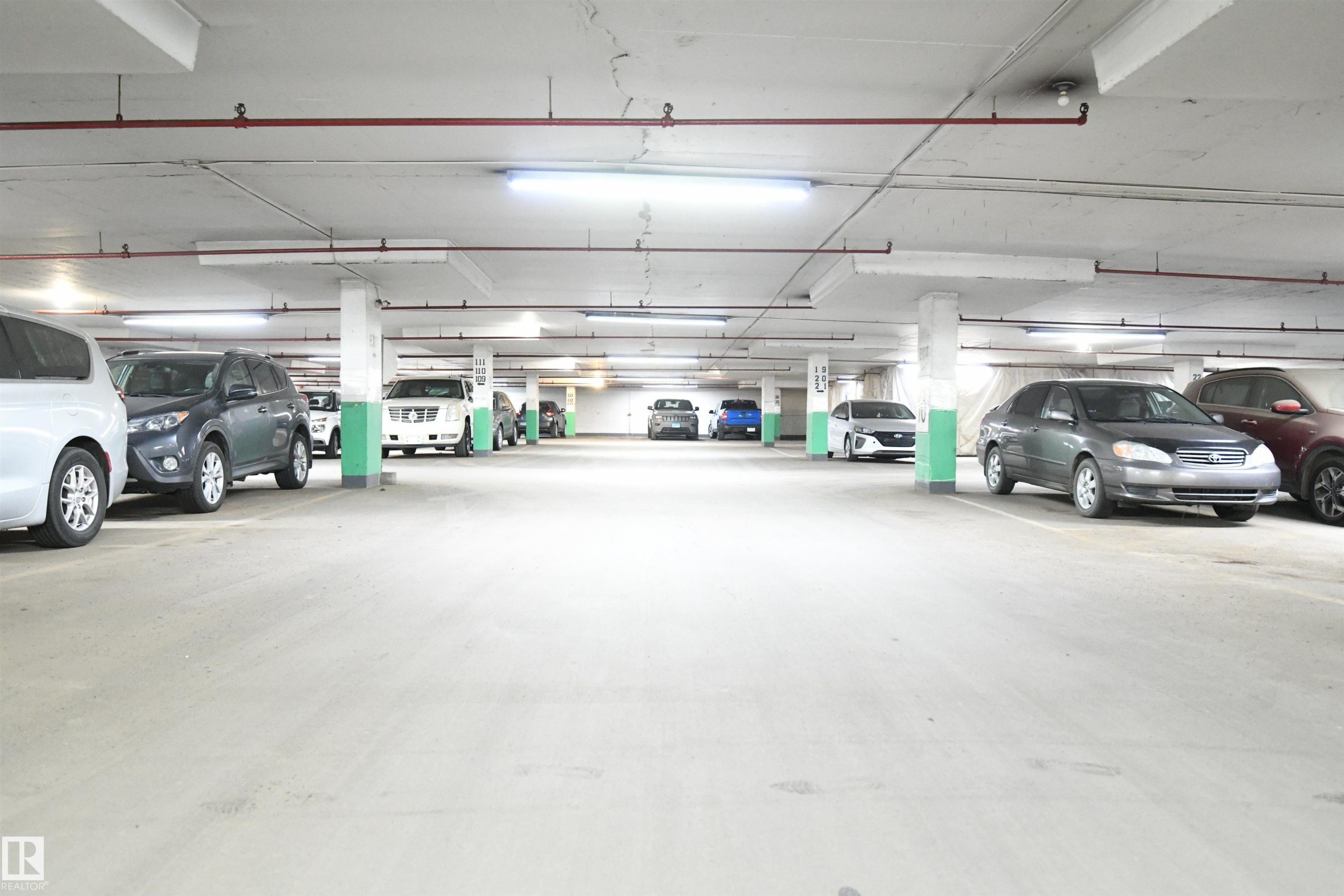 The secured, heated parkade is bright and open, with wide drive aisles, and easy driving access - #1305 13910 Stony Plain Rd Nw, Edmonton, AB - Indoor Photo Showing Garage