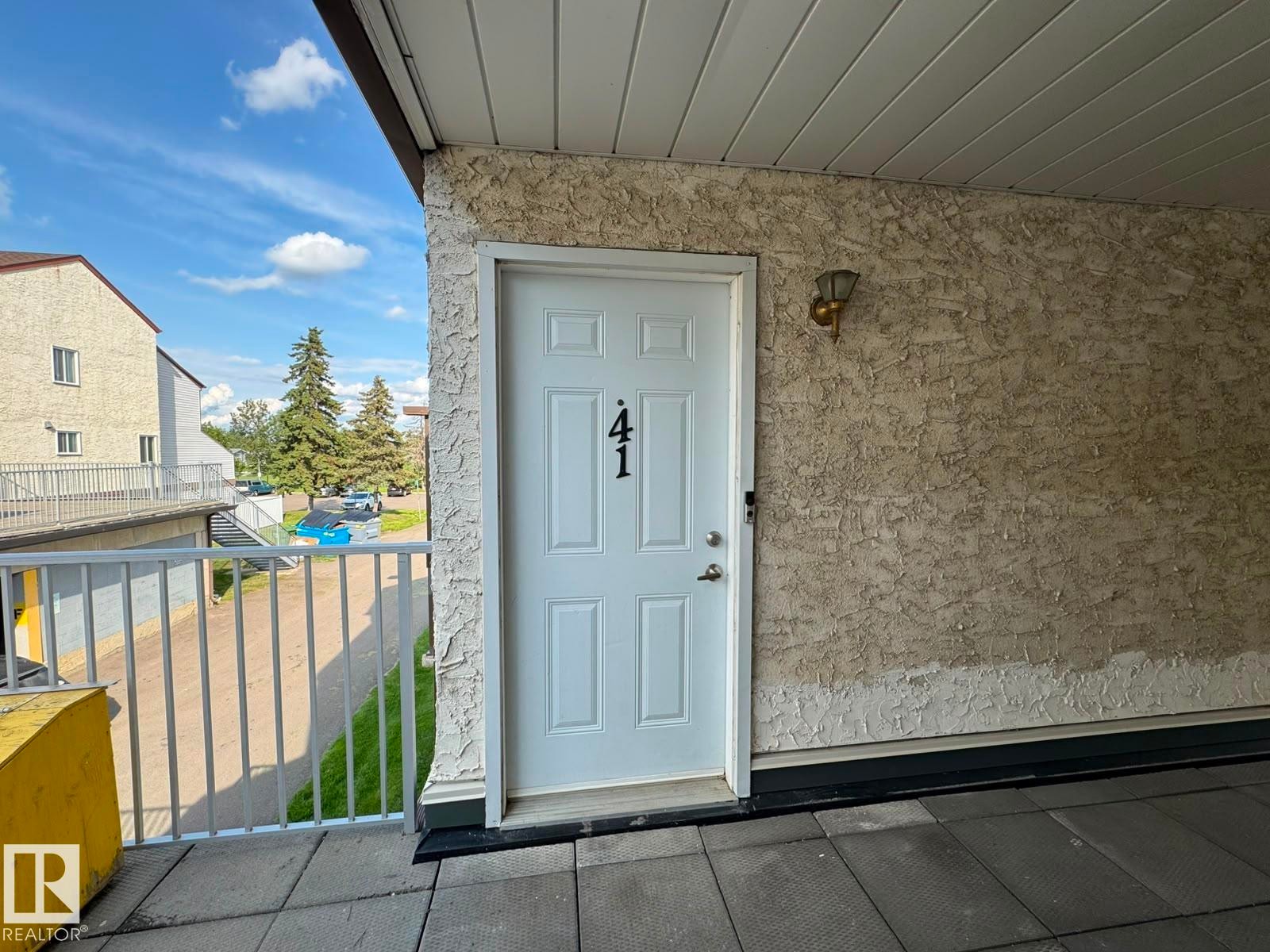 White paneled entry door with exterior wall sconce - 41 Lancaster Terrace Nw, Edmonton, AB - Outdoor With Exterior