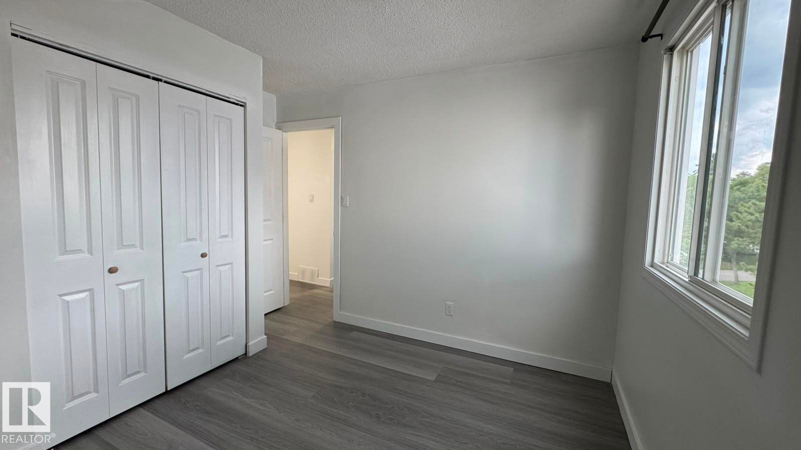 Wood-finish flooring, white walls, and a large window providing ample natural light - 41 Lancaster Terrace Nw, Edmonton, AB - Indoor Photo Showing Other Room