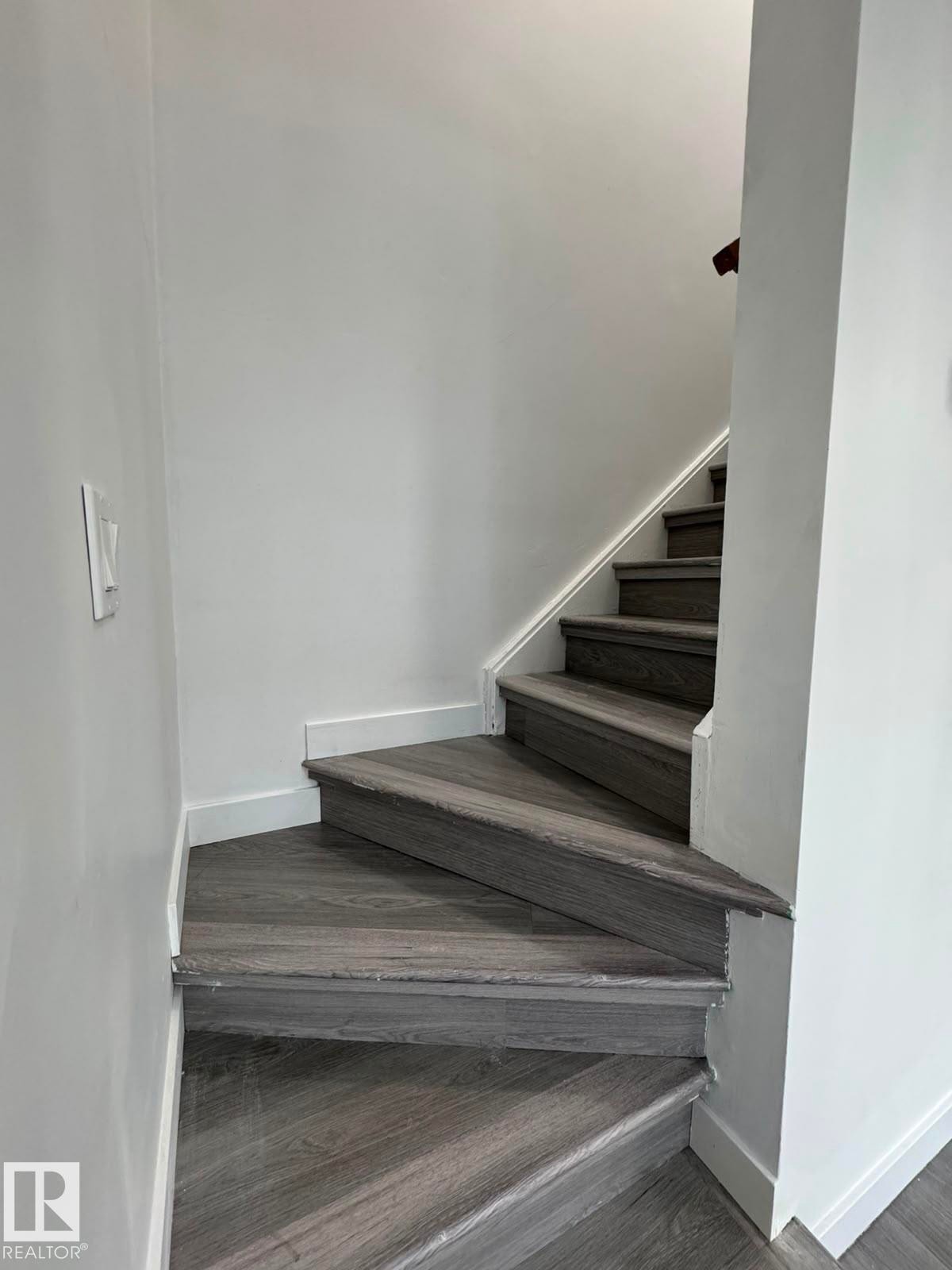 Staircase featuring wood-finish treads and risers, white wall paint, and white trim - 41 Lancaster Terrace Nw, Edmonton, AB - Indoor Photo Showing Other Room