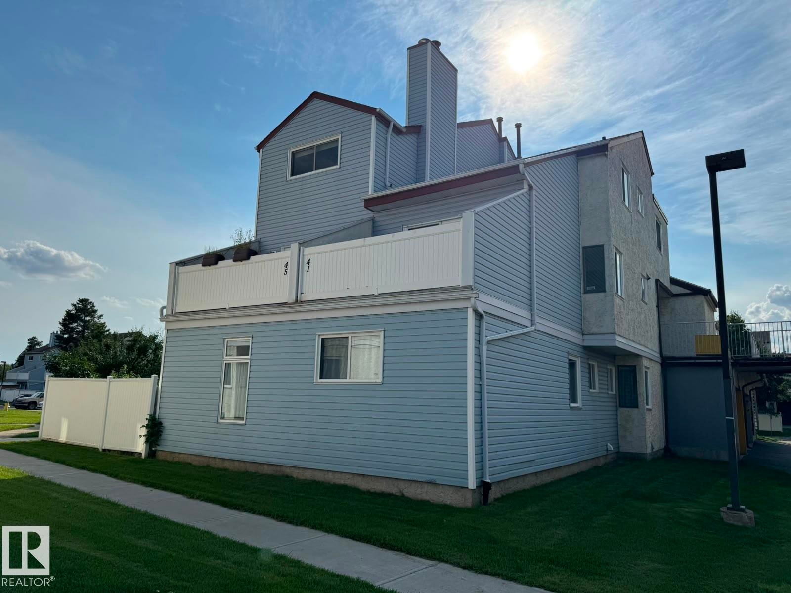 Light blue siding exterior with a white upper-level balcony railing - 41 Lancaster Terrace Nw, Edmonton, AB - Outdoor With Exterior