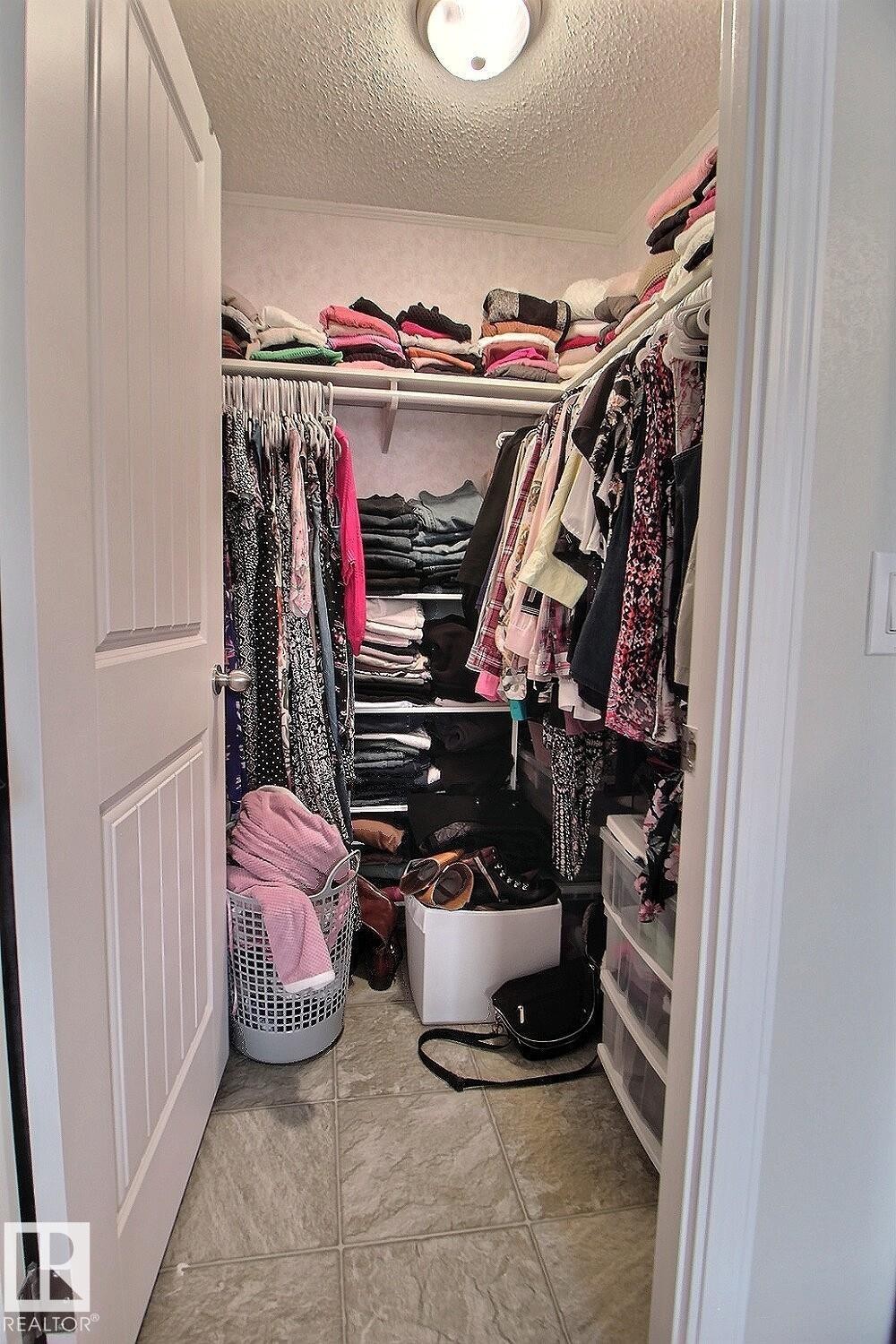 Walk-in closet featuring tile flooring, built-in shelving, and a ceiling-mounted light fixture - 417 Oak Wood Crescent Northwest, Edmonton, AB - Indoor With Storage