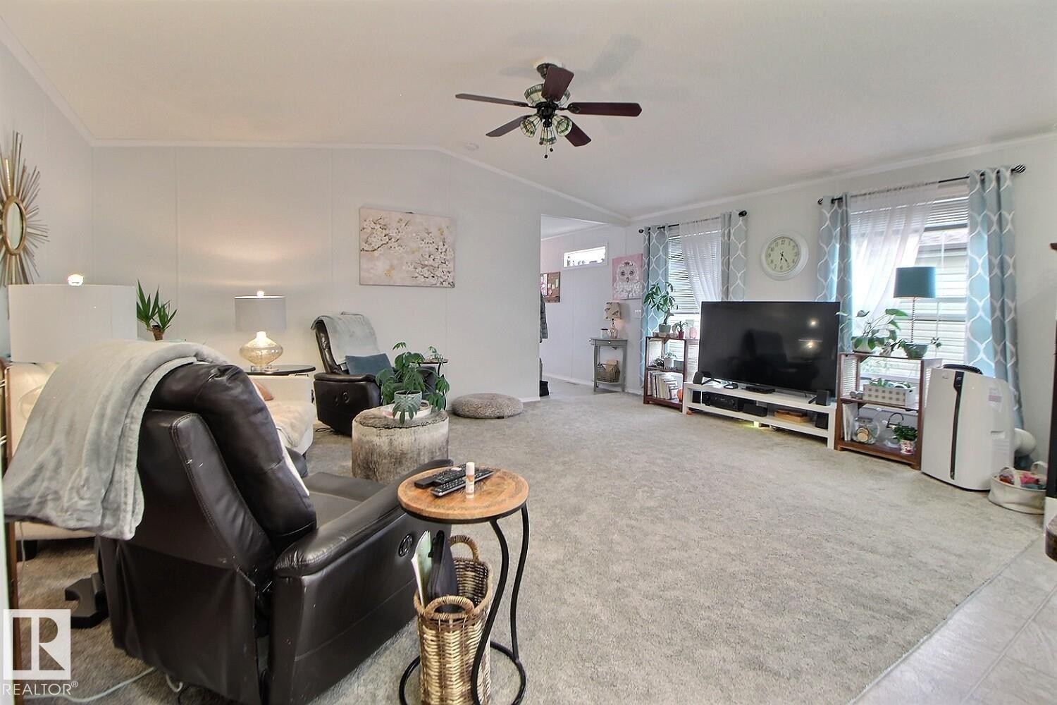 Spacious living area featuring light gray carpeting, neutral wall colors, and a ceiling fan with integrated lighting - 417 Oak Wood Crescent Northwest, Edmonton, AB - Indoor Photo Showing Living Room