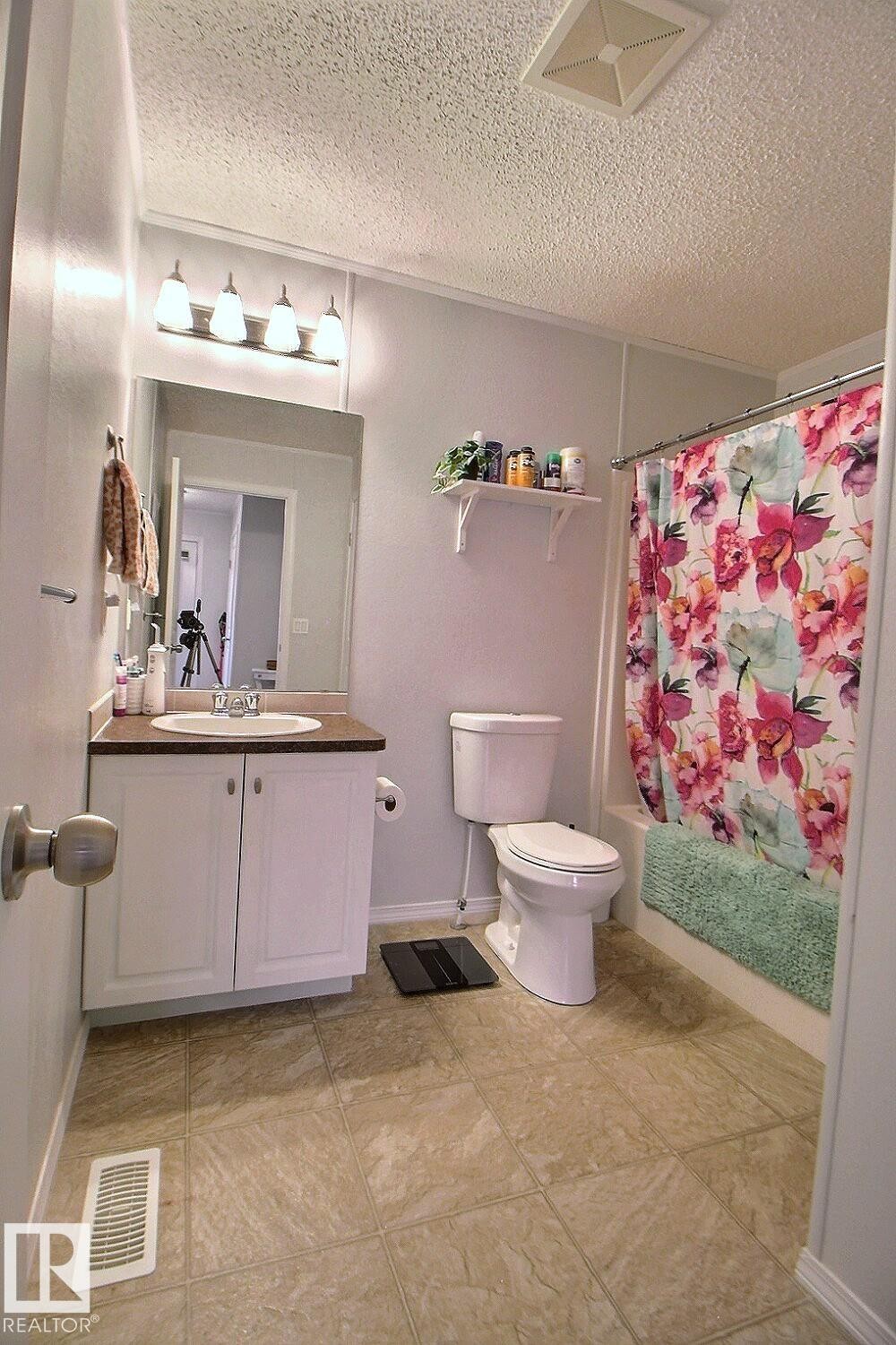 Bathroom with a white vanity, integrated sink, and wall-mounted lighting fixture - 417 Oak Wood Crescent Northwest, Edmonton, AB - Indoor Photo Showing Bathroom