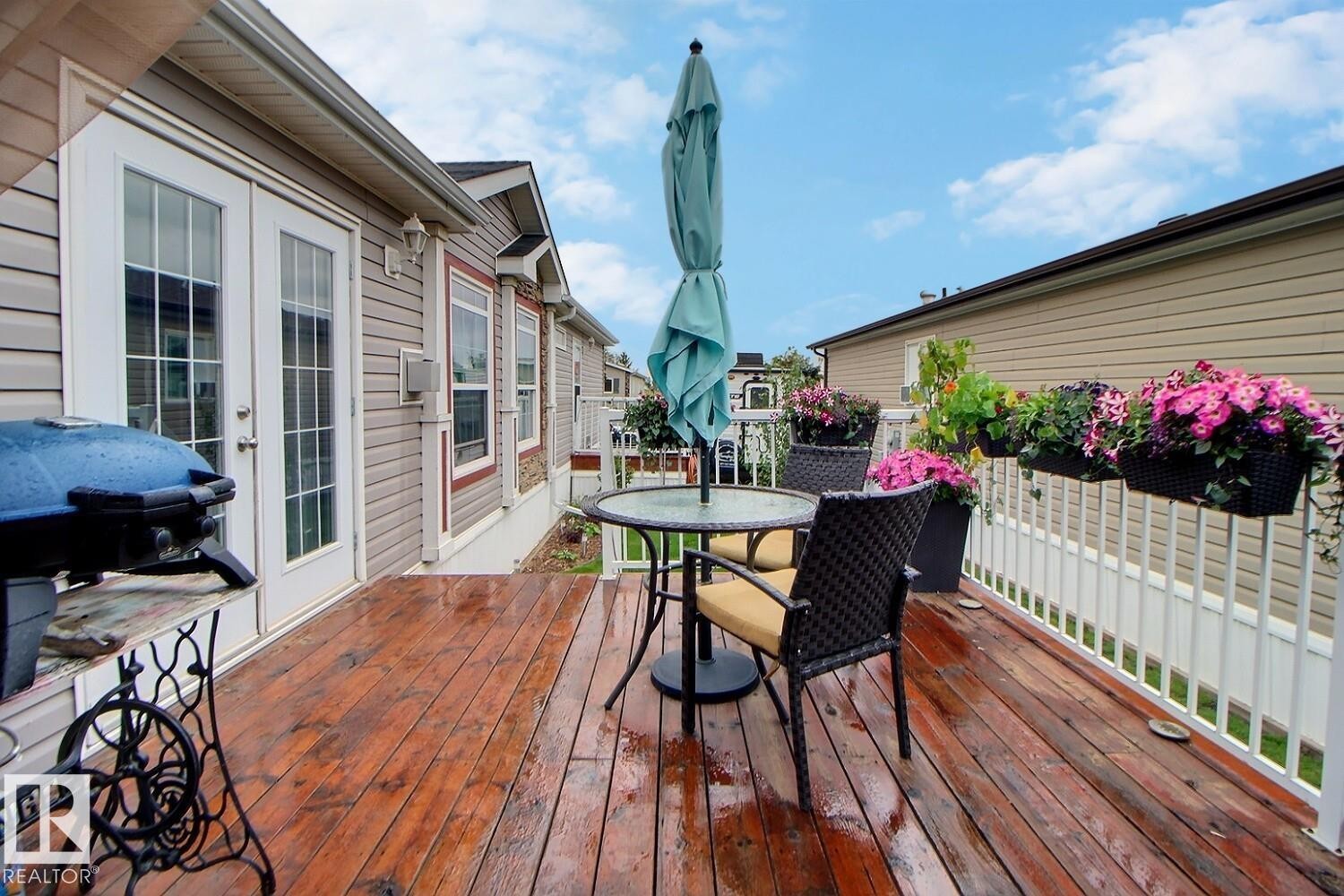 Expansive wood-finish deck with a white railing, featuring exterior wall siding, and double French doors with glass panels - 417 Oak Wood Crescent Northwest, Edmonton, AB - Outdoor With Deck Patio Veranda With Exterior