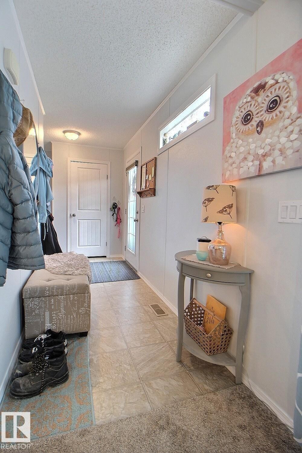 Hallway featuring mixed flooring, a white paneled door, and an overhead transom window - 417 Oak Wood Crescent Northwest, Edmonton, AB - Indoor Photo Showing Other Room