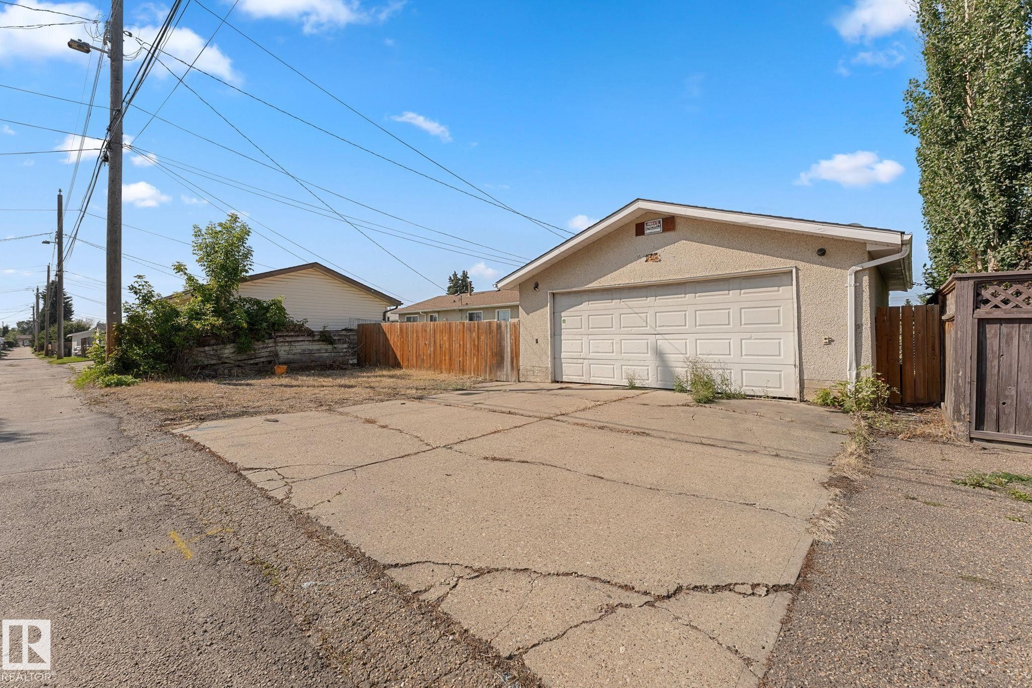 Detached garage featuring a white panel door and stucco exterior - 7823 136 Avenue Nw, Edmonton, AB - Outdoor