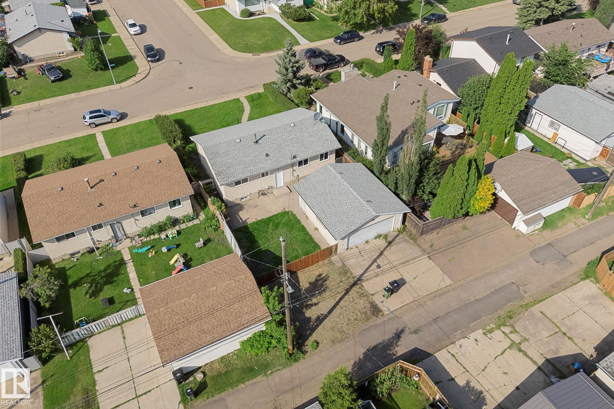 Two-story residence with a brown shingle roof, a detached garage with a brown shingle roof, and a fenced backyard - 7823 136 Avenue Nw, Edmonton, AB - Outdoor With View