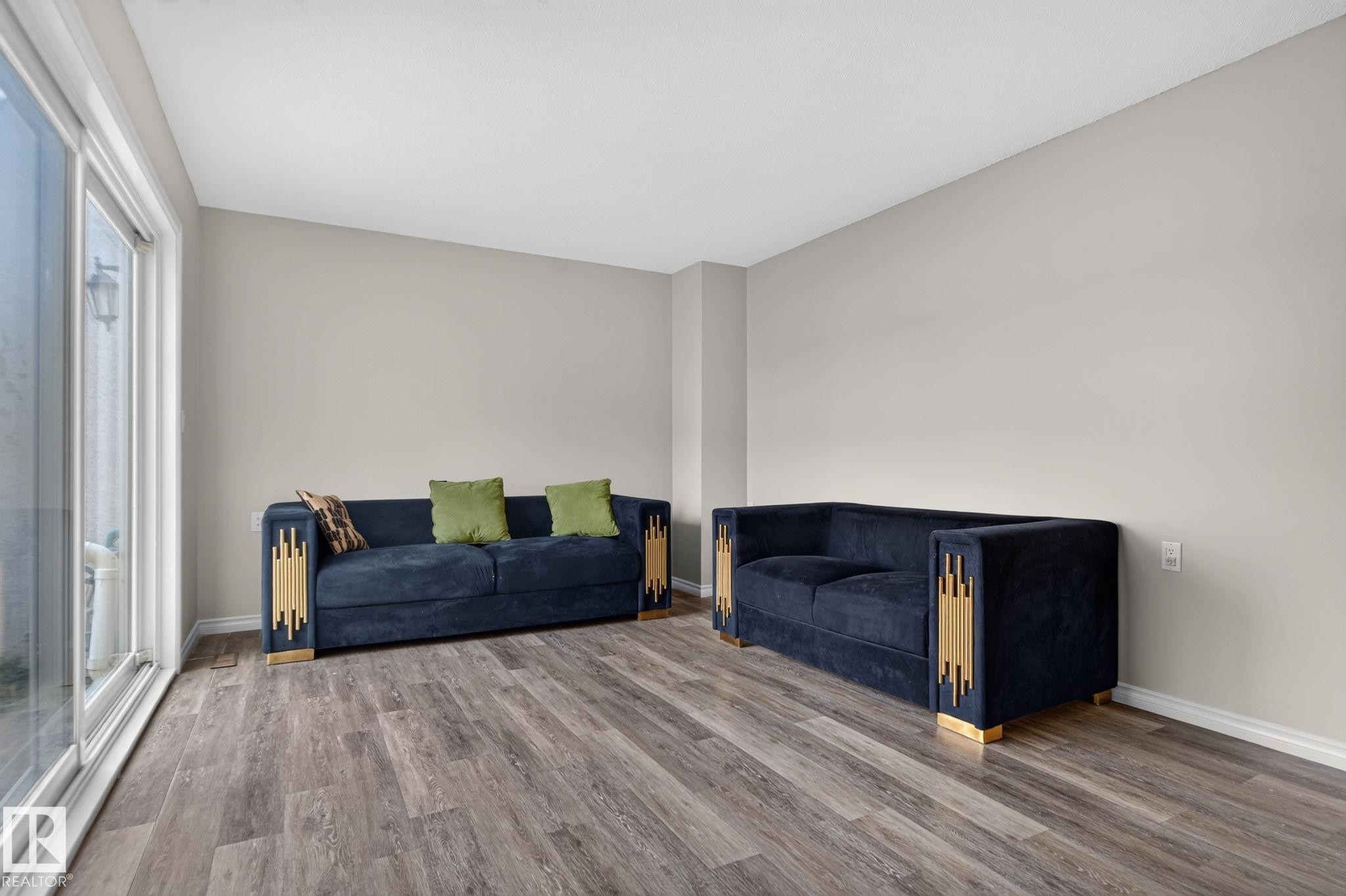Wood-finish flooring, light neutral wall paint, and sliding glass patio doors - 17775 95 Street Nw, Edmonton, AB - Indoor