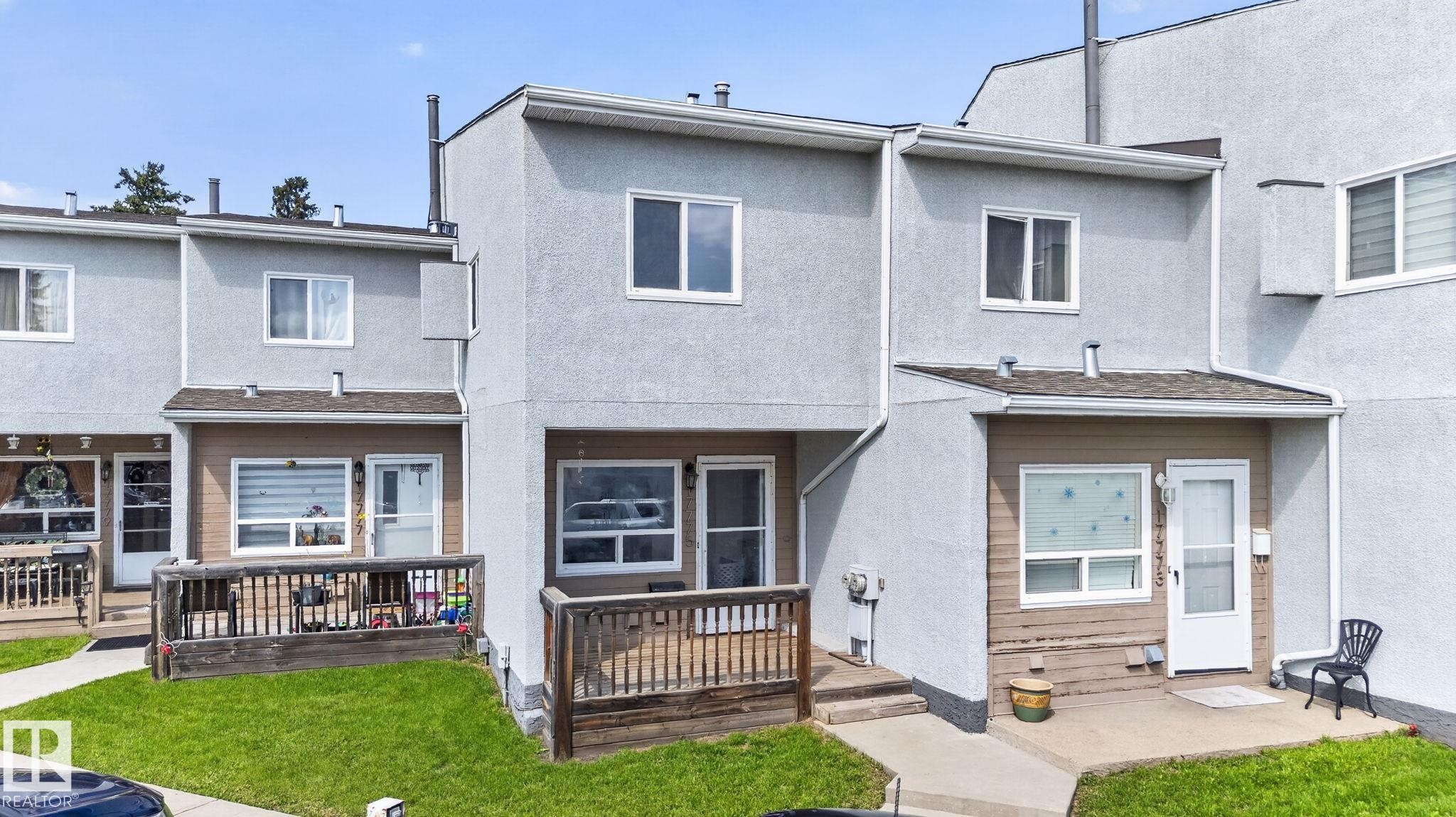 Stucco exterior with multiple windows, individual front entries, and a private wooden deck - 17775 95 Street Nw, Edmonton, AB - Outdoor