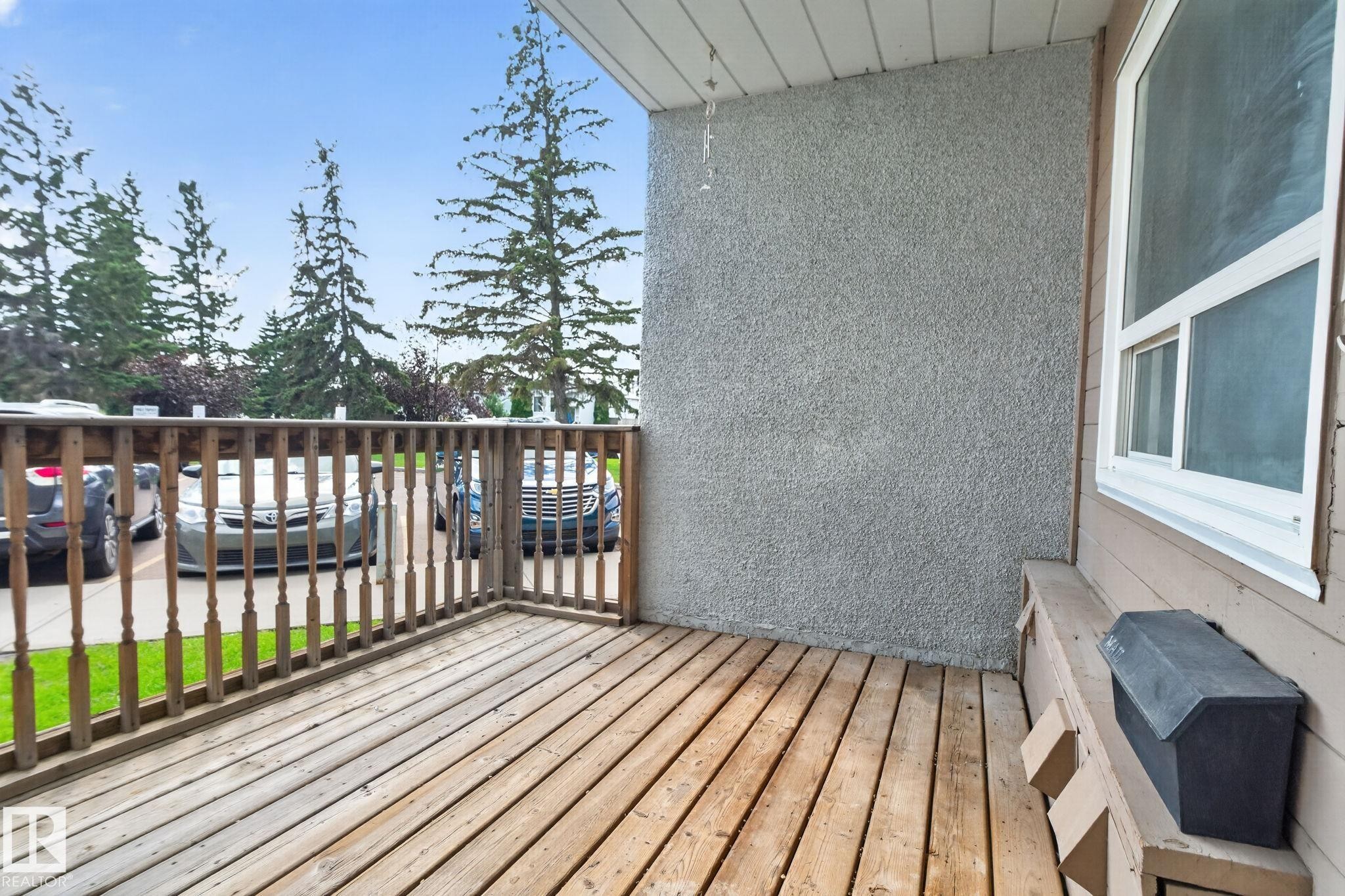 Wooden deck with spindle railing, stucco exterior wall, and white-framed window - 17775 95 Street Nw, Edmonton, AB - Outdoor With Deck Patio Veranda With Exterior