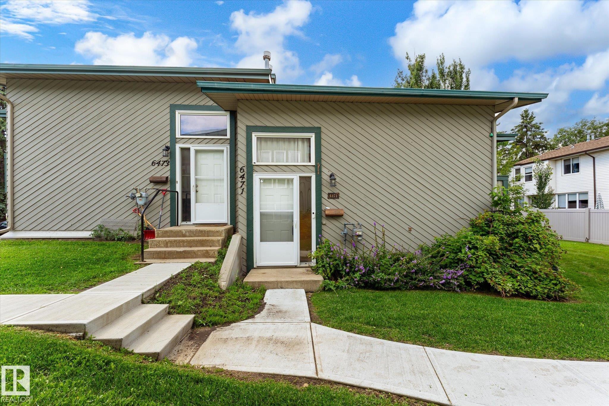 Two separate entrances, each with a white exterior door and an overhead transom window - 6471 180 Street Nw, Edmonton, AB - Outdoor