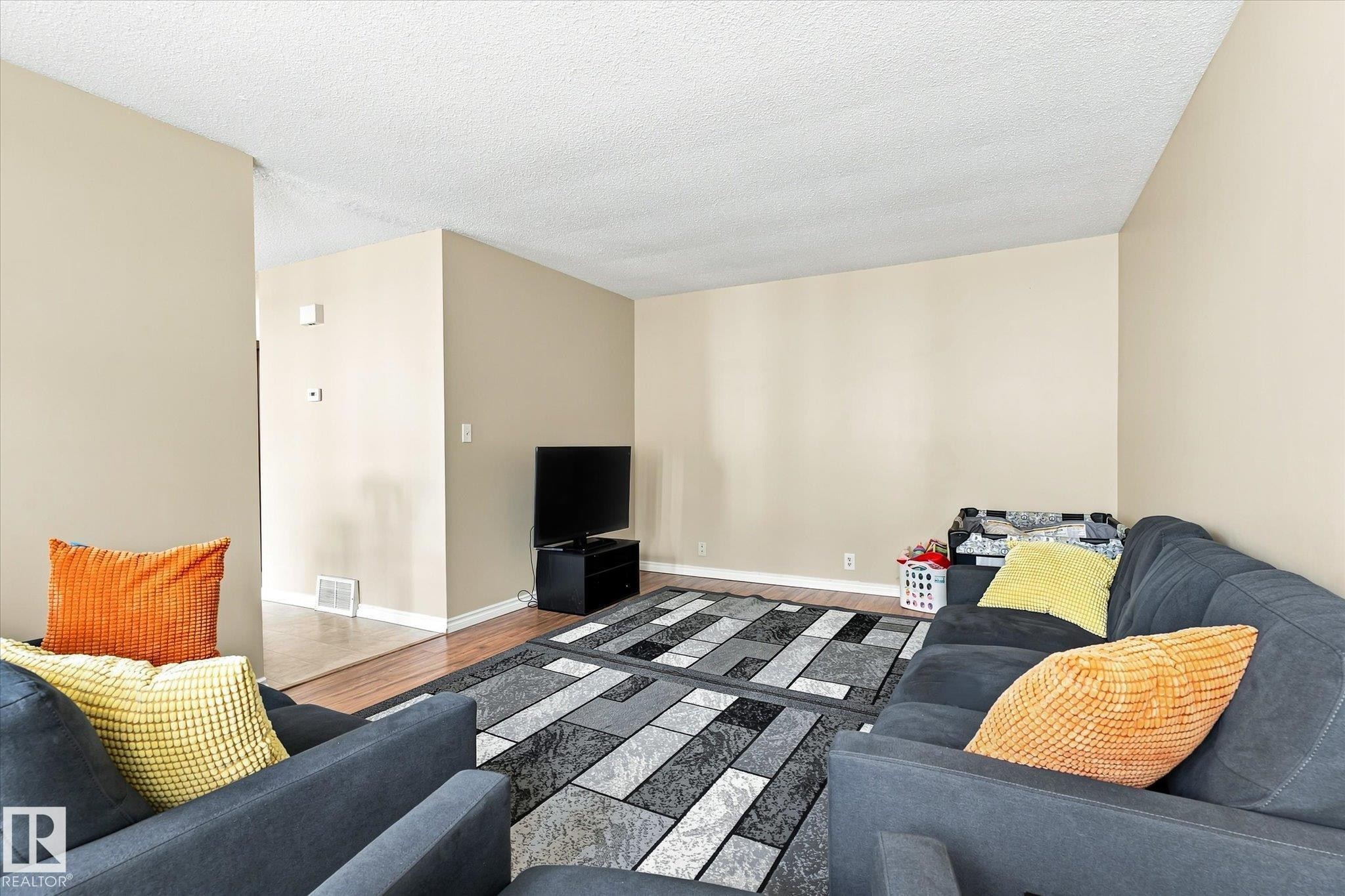 Wood-finish flooring with a neutral wall palette - 6471 180 Street Nw, Edmonton, AB - Indoor Photo Showing Living Room