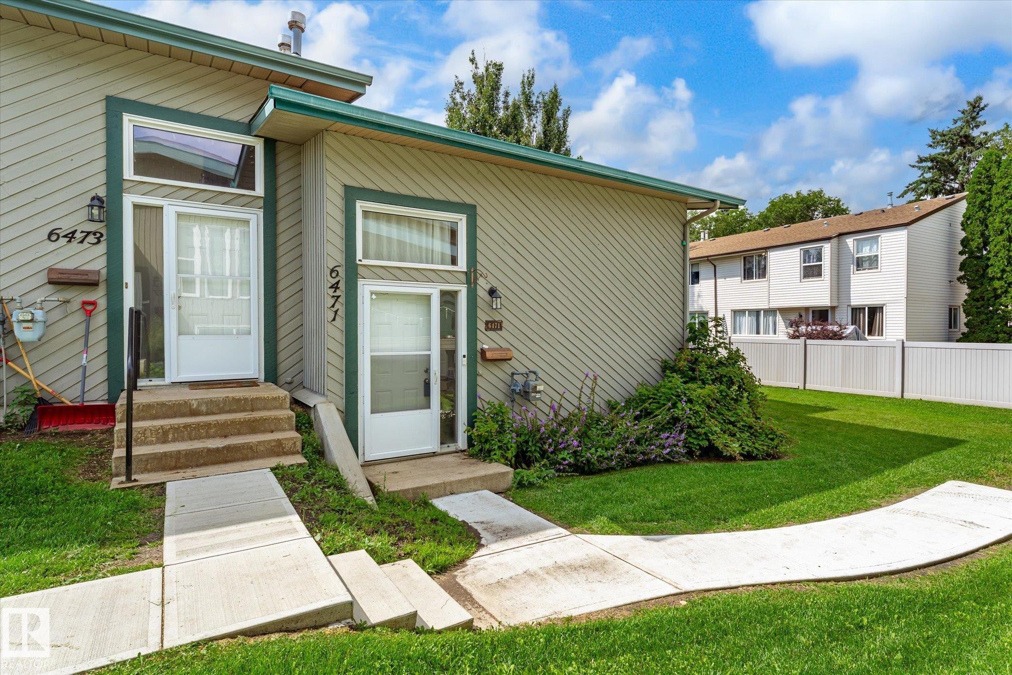 Siding exterior with green trim, individual entrances, and concrete walkways - 6471 180 Street Nw, Edmonton, AB - Outdoor