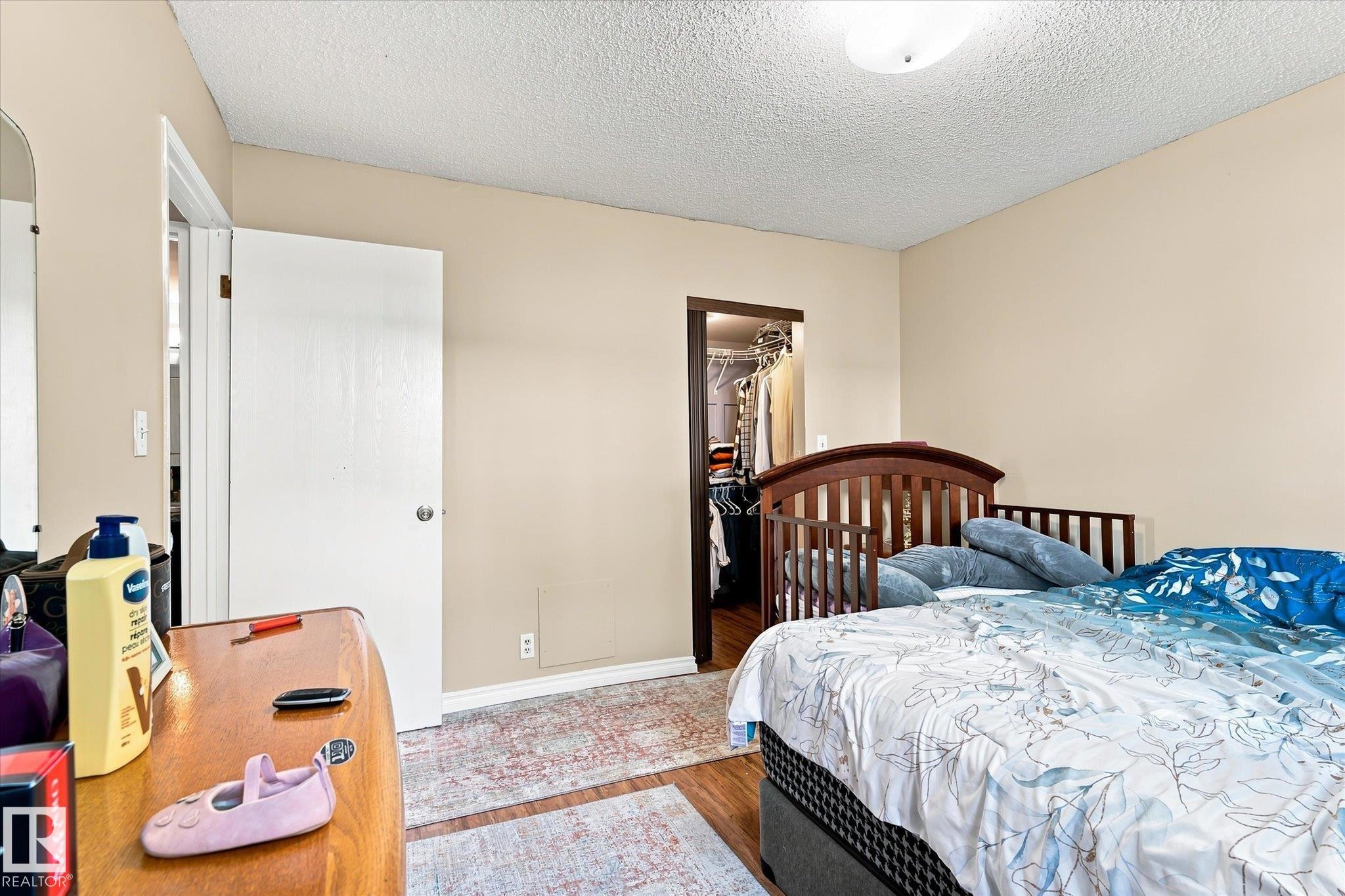 Wood-finish flooring with light beige wall paint - 6471 180 Street Nw, Edmonton, AB - Indoor Photo Showing Bedroom