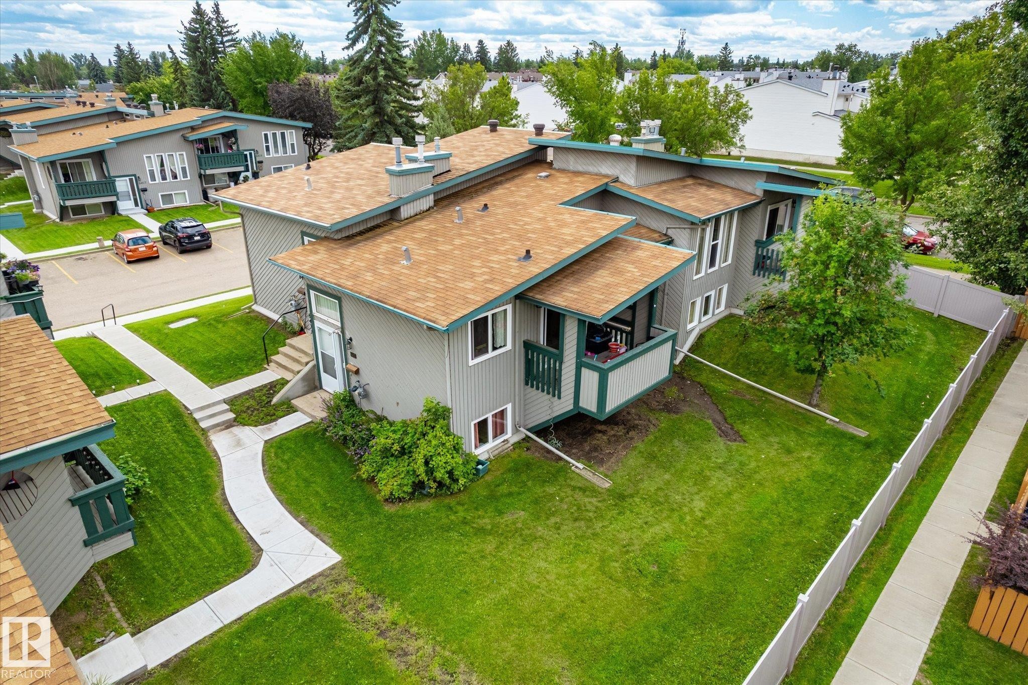 Multi-level residential building featuring gray siding and a brown shingle roof - 6471 180 Street Nw, Edmonton, AB - Outdoor