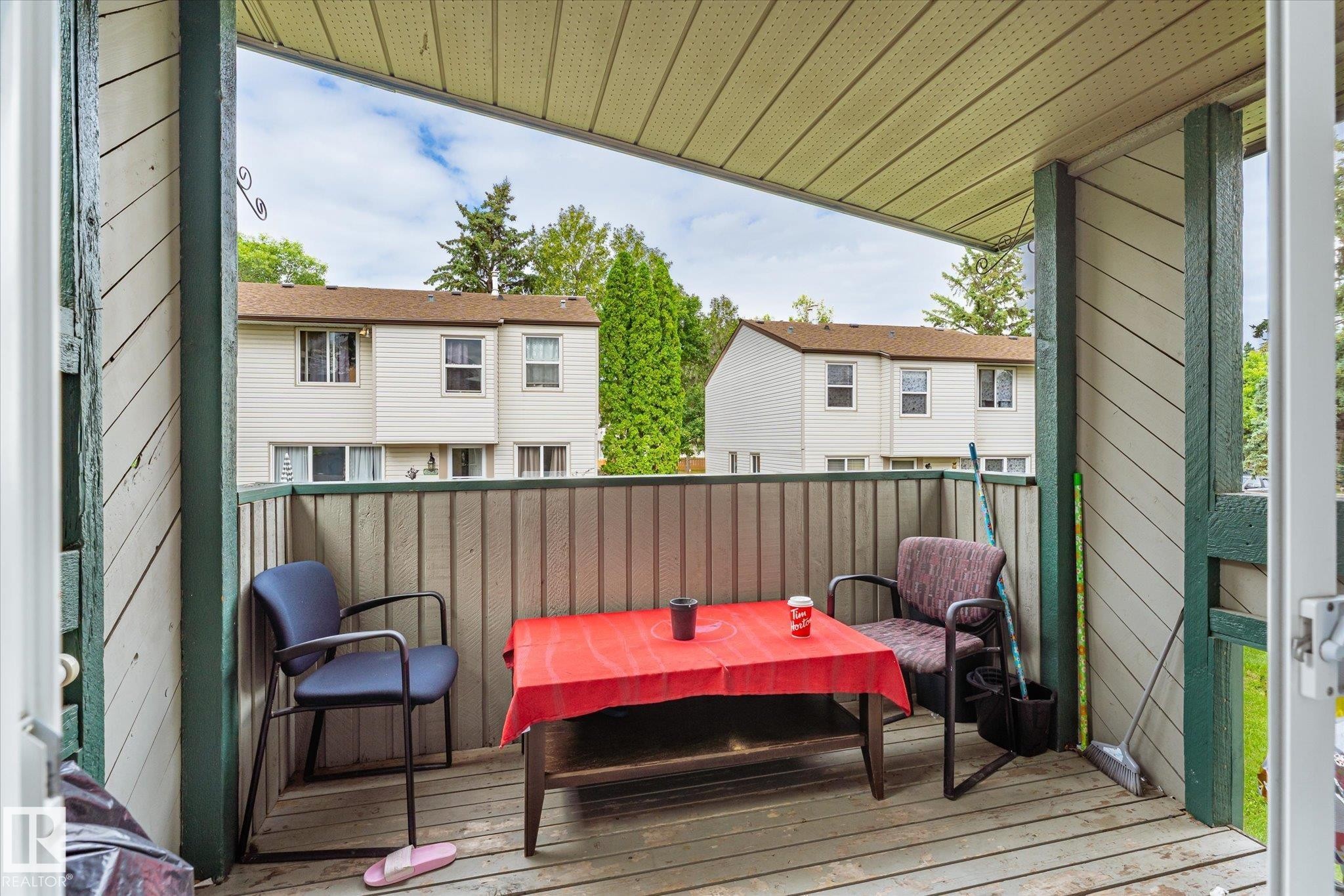 Covered balcony featuring wood-finish flooring and a slatted privacy wall - 6471 180 Street Nw, Edmonton, AB - Outdoor With Deck Patio Veranda With Exterior