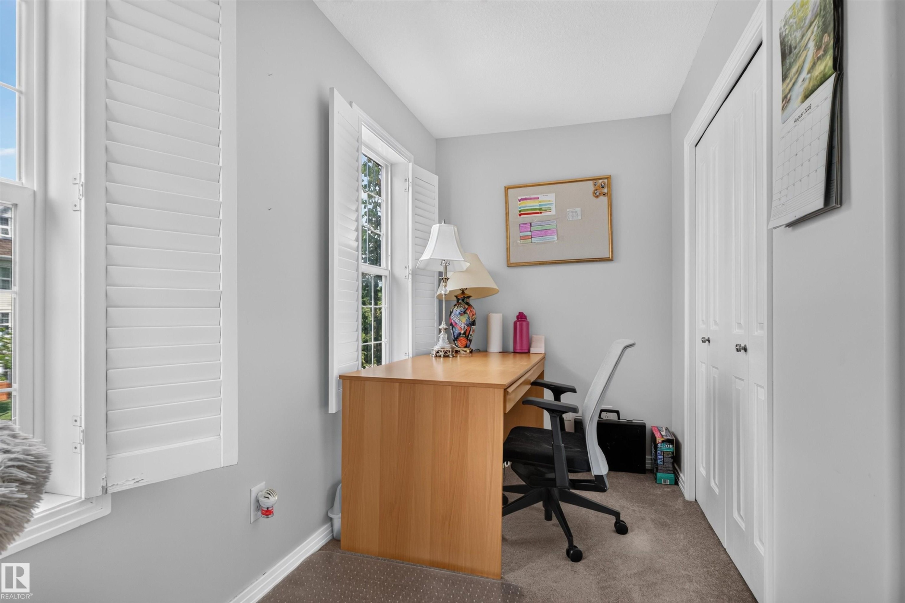 Two double-hung windows with plantation shutters, neutral wall color, and a bi-fold closet door - 4471 Mccrae Avenue Nw, Edmonton, AB