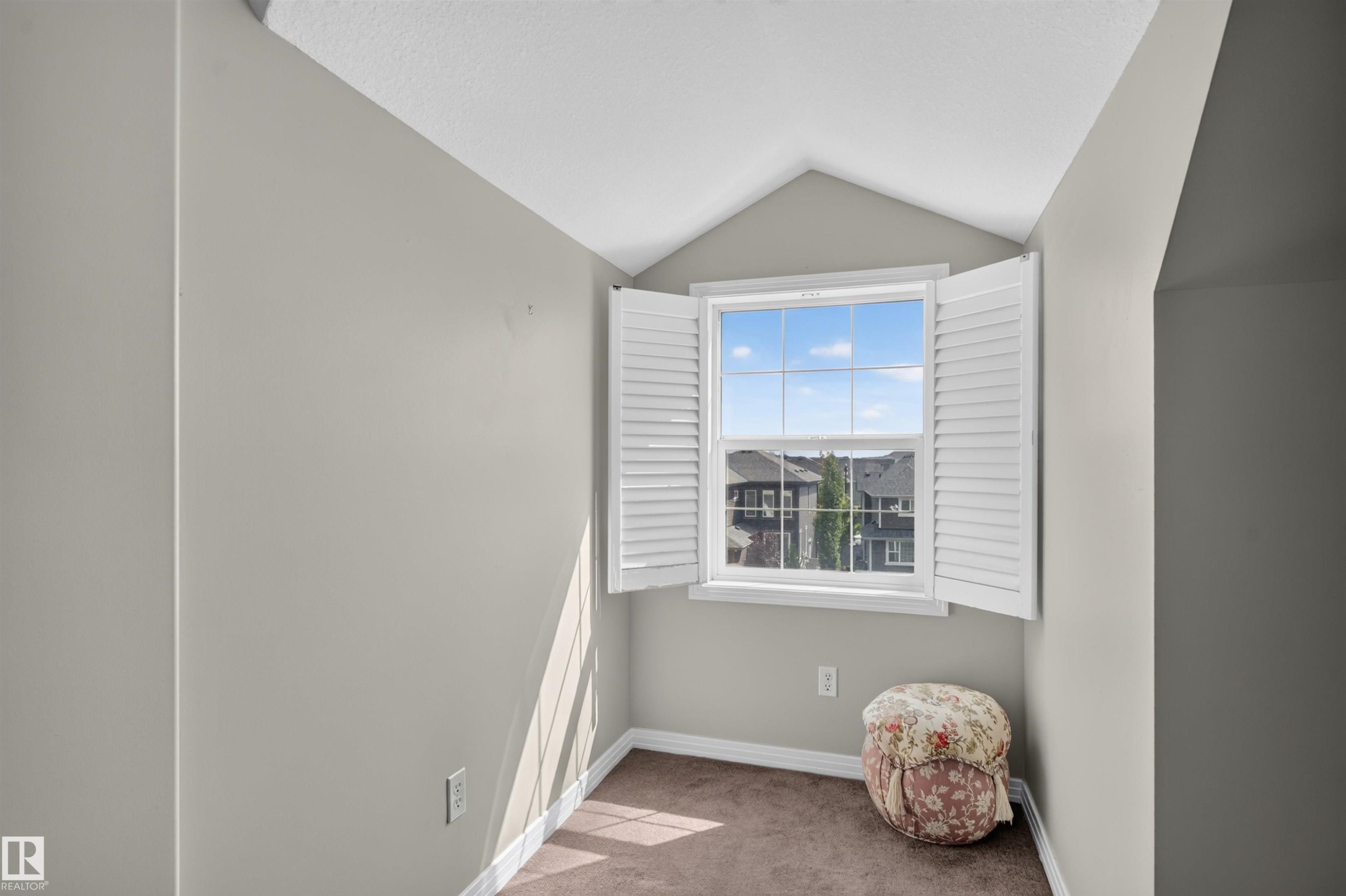 Window with white plantation shutters, neutral wall paint, and brown carpet flooring - 4471 Mccrae Avenue Nw, Edmonton, AB