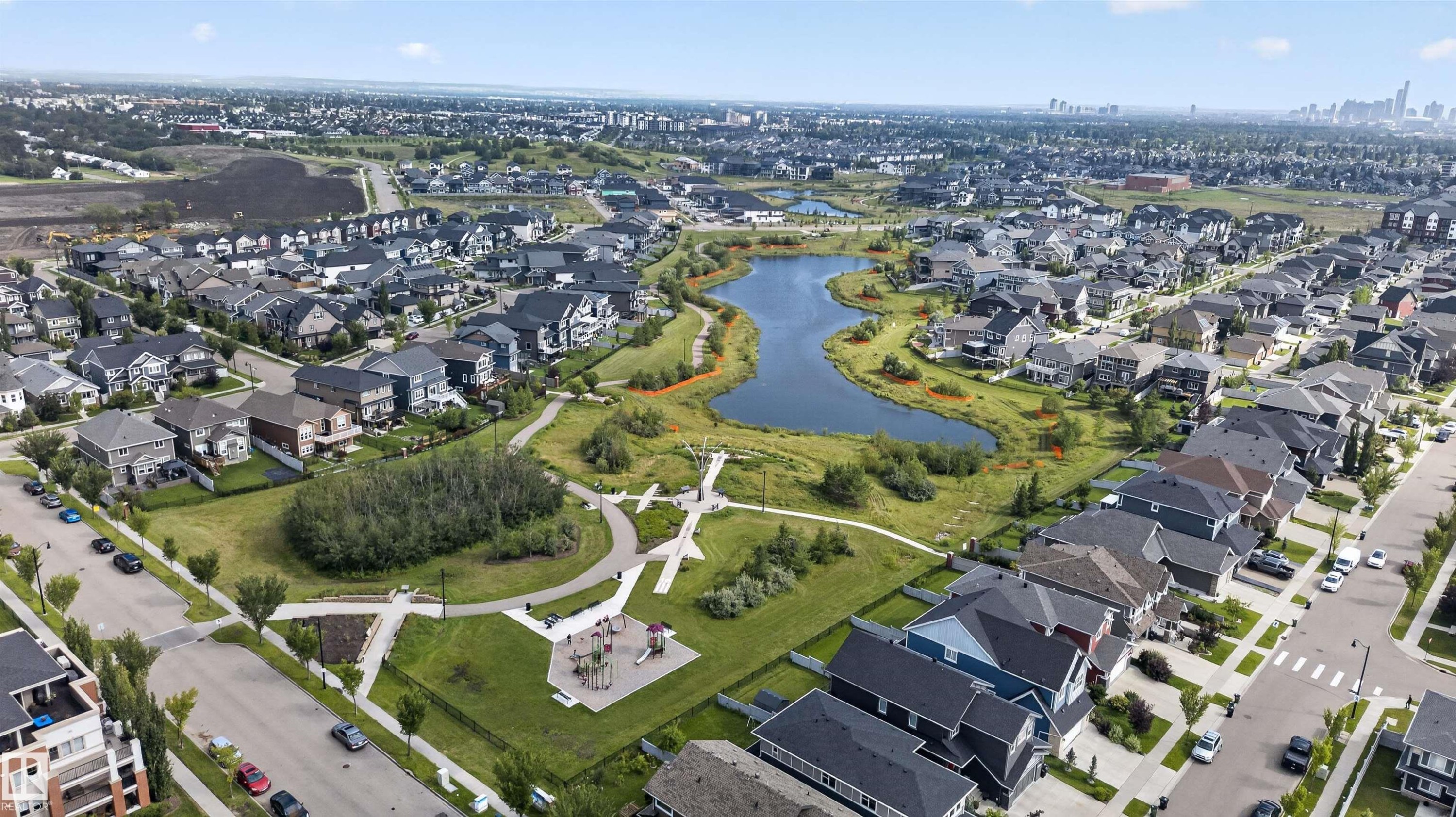 Established residential community with a central water feature, adjacent green spaces, and a visible playground - 4471 Mccrae Avenue Nw, Edmonton, AB